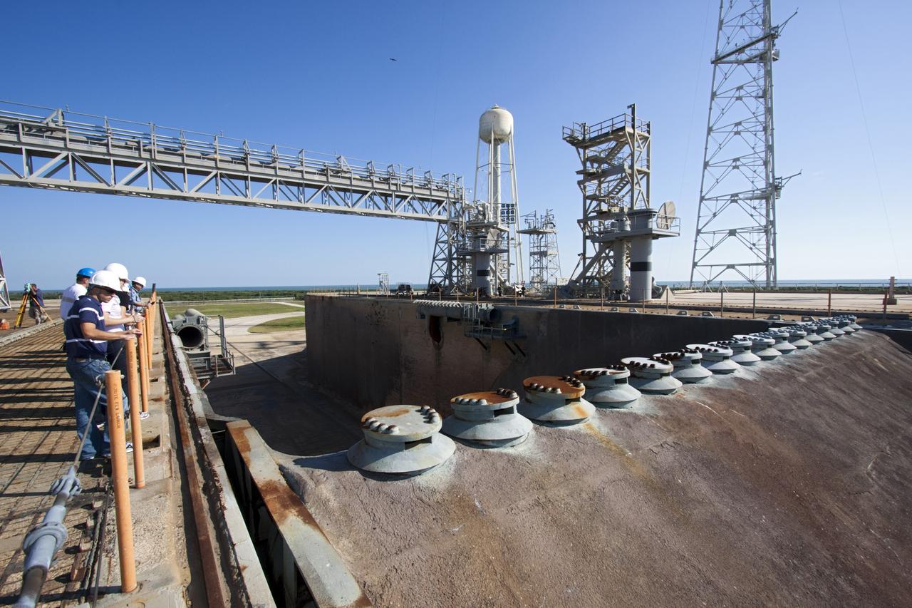 CAPE CANAVERAL, Fla. – Mechanical engineering students from Louisiana State University joined engineers and scientists at Launch Pad 39B at NASA's Kennedy Space Center in Florida as the students toured the facility to have a look at the flame trench. Designers are looking for new, flame and vibration-resistant materials to line the trench. To help in the search, a team of mechanical engineering students at Louisiana State University are to build a scaled-down version of the flame trench that Kennedy's scientists can use to try out sample materials for the trench. If the samples work in the lab, they can be tried out in the real flame trenches at Launch Pad 39A and 39B.    The launch pad has been refurbished extensively and work is continuing to modify the pad to support a variety of launch vehicles in the future. Photo credit:  NASA/Jim Grossmann