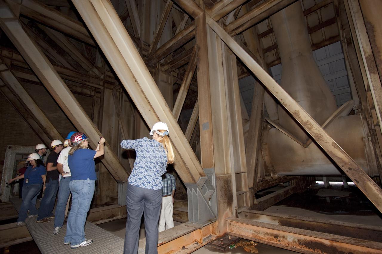 CAPE CANAVERAL, Fla. – Mechanical engineering students from Louisiana State University joined engineers and scientists at Launch Pad 39B at NASA's Kennedy Space Center in Florida as the students toured the facility to have a look at the flame trench. They went inside the pad structure to the area inside the flame deflector which divides the flame trench and funnels exhaust away from a shuttle at liftoff. The flame deflector, which is about 40-feet tall, is essentially hollow inside and braced by steel beams. The students signed up to help designers looking for new, flame and vibration-resistant materials to line the trench. The students are to build a scaled-down version of the flame trench that Kennedy's scientists can use to try out sample materials for the trench. If the samples work in the lab, they can be tried out in the real flame trenches at Launch Pad 39A and 39B.    The launch pad has been refurbished extensively and work is continuing to modify the pad to support a variety of launch vehicles in the future. Photo credit:  NASA/Jim Grossmann