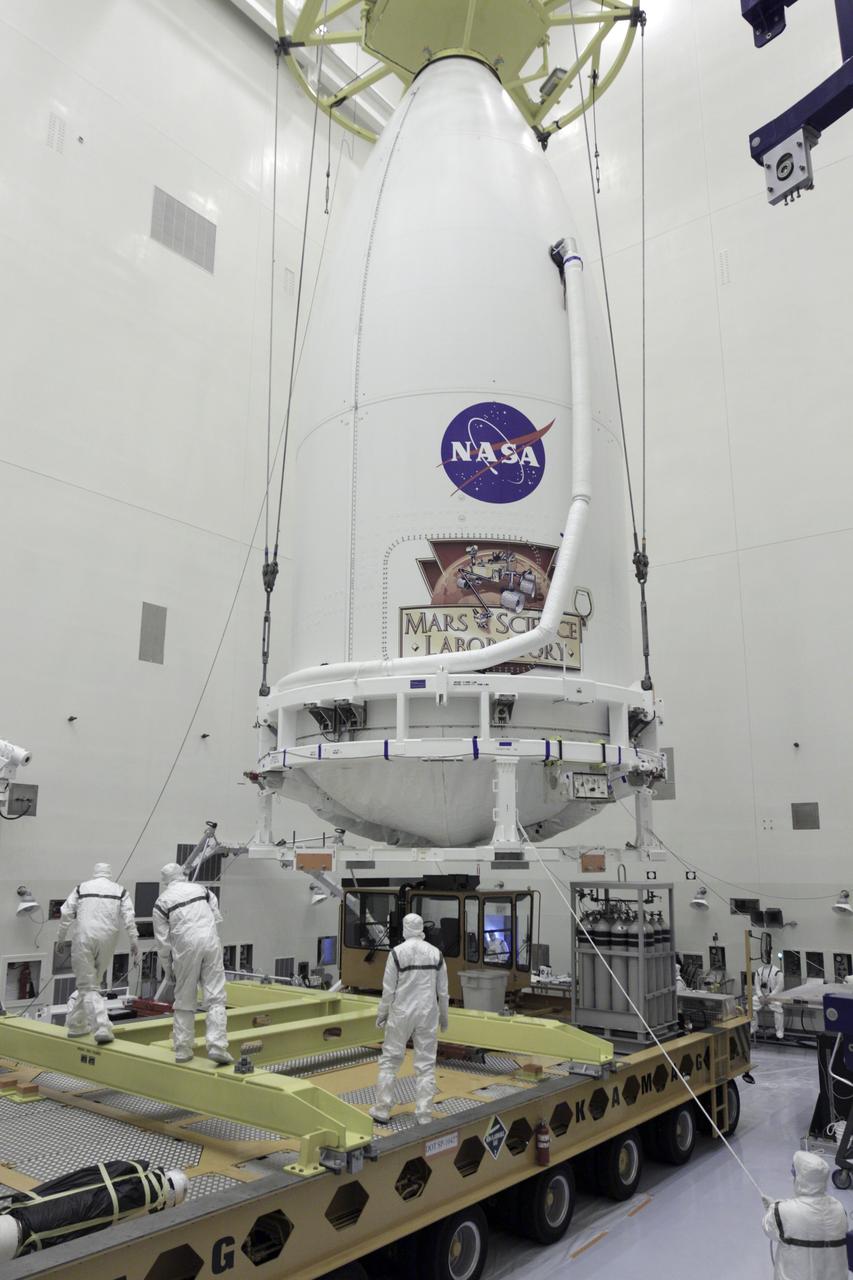 CAPE CANAVERAL, Fla. -- In the Payload Hazardous Servicing Facility at NASA's Kennedy Space Center in Florida, technicians assist as the payload fairing of an Atlas V rocket approaches a transporter for the move to Space Launch Complex 41. The Mars Science Laboratory (MSL) spacecraft is enclosed in the fairing, which will protect the payload from heat and aerodynamic pressure generated during launch. MSL's components include a compact car-sized rover, Curiosity, which has 10 science instruments designed to search for evidence on whether Mars has had environments favorable to microbial life, including the chemical ingredients for life. The unique rover will use a laser to look inside rocks and release its gasses so that the rover’s spectrometer can analyze and send the data back to Earth. Launch of MSL aboard a United Launch Alliance Atlas V rocket is planned for Nov. 25 from Space Launch Complex-41 on Cape Canaveral Air Force Station. For more information, visit http://www.nasa.gov/msl. Photo credit: NASA/Kim Shiflett