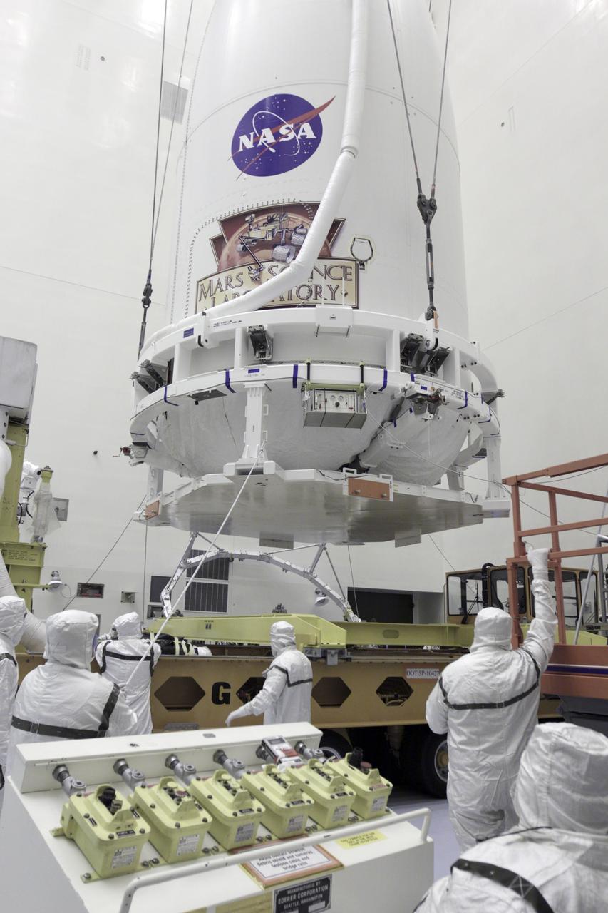 CAPE CANAVERAL, Fla. -- In the Payload Hazardous Servicing Facility at NASA's Kennedy Space Center in Florida, technicians help guide an Atlas V rocket's payload fairing down to the surface of a transporter for the move to Space Launch Complex 41. The Mars Science Laboratory (MSL) spacecraft is enclosed in the fairing, which will protect the payload from heat and aerodynamic pressure generated during launch. MSL's components include a compact car-sized rover, Curiosity, which has 10 science instruments designed to search for evidence on whether Mars has had environments favorable to microbial life, including the chemical ingredients for life. The unique rover will use a laser to look inside rocks and release its gasses so that the rover’s spectrometer can analyze and send the data back to Earth. Launch of MSL aboard a United Launch Alliance Atlas V rocket is planned for Nov. 25 from Space Launch Complex-41 on Cape Canaveral Air Force Station. For more information, visit http://www.nasa.gov/msl. Photo credit: NASA/Kim Shiflett