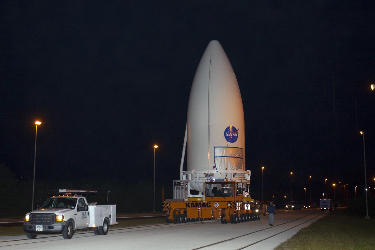 CAPE CANAVERAL, Fla. -- Standing atop a payload transporter, the Atlas V payload fairing containing NASA's Mars Science Laboratory (MSL) spacecraft rolls down a darkened roadway during the early morning move from Kennedy Space Center's Payload Hazardous Servicing Facility to Space Launch Complex 41. The fairing will protect the payload from heat and aerodynamic pressure generated during launch. MSL's components include a compact car-sized rover, Curiosity, which has 10 science instruments designed to search for evidence on whether Mars has had environments favorable to microbial life, including the chemical ingredients for life. The unique rover will use a laser to look inside rocks and release its gasses so that the rover’s spectrometer can analyze and send the data back to Earth. Launch of MSL aboard a United Launch Alliance Atlas V rocket is planned for Nov. 25 from Space Launch Complex 41 on Cape Canaveral Air Force Station. For more information, visit http://www.nasa.gov/msl. Photo credit: NASA/Kim Shiflett