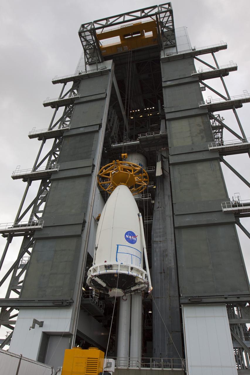CAPE CANAVERAL, Fla. -- At Space Launch Complex 41, the payload fairing containing NASA's Mars Science Laboratory (MSL) spacecraft is lifted up the side of the Vertical Integration Facility, where it will be attached to the Atlas V rocket already stacked inside. MSL was prepared for launch in the Payload Hazardous Servicing Facility at NASA's Kennedy Space Center. MSL's components include a compact car-sized rover, Curiosity, which has 10 science instruments designed to search for evidence on whether Mars has had environments favorable to microbial life, including the chemical ingredients for life. The unique rover will use a laser to look inside rocks and release its gasses so that the rover’s spectrometer can analyze and send the data back to Earth. Launch of MSL aboard a United Launch Alliance Atlas V rocket is planned for Nov. 25 from Space Launch Complex 41 on Cape Canaveral Air Force Station. For more information, visit http://www.nasa.gov/msl. Photo credit: NASA/Kim Shiflett