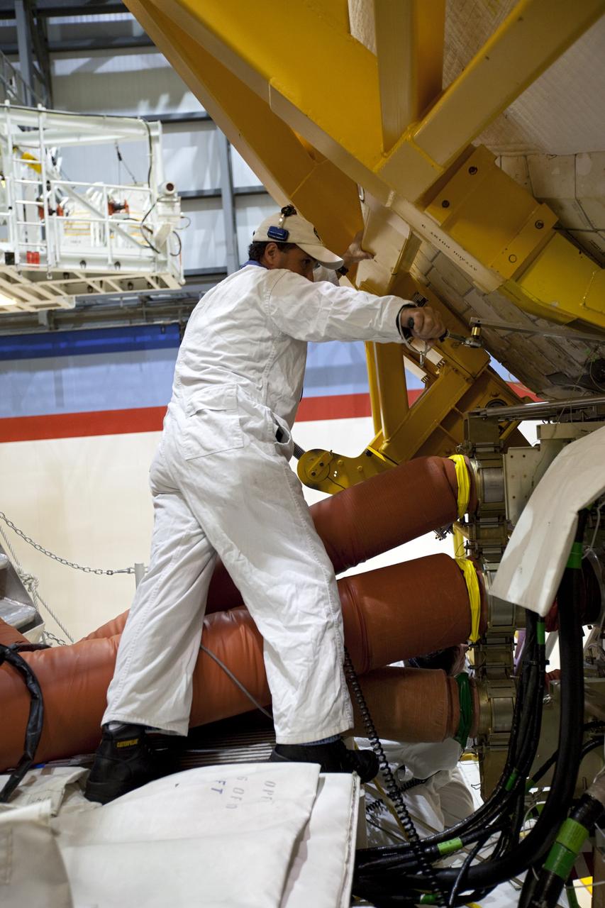 CAPE CANAVERAL, Fla. --Inside Orbiter Processing Facility-2 at NASA’s Kennedy Space Center in Florida, technicians help secure a sling around space shuttle Atlantis’ right orbital maneuvering system (OMS) pod.       The work is part of the Space Shuttle Program’s transition and retirement processing of shuttle Atlantis. The OMS pod will be removed and sent to White Sands Space Harbor in New Mexico where it will undergo a complete deservicing and cleaning and then be returned to Kennedy for reinstallation on Atlantis. Atlantis is being prepared for display at the Kennedy Space Center Visitor Complex.  Photo credit: NASA/Dimitri Gerondidakis