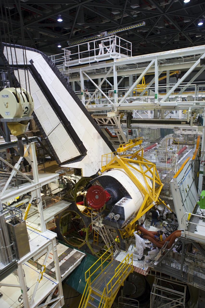 CAPE CANAVERAL, Fla. -- Inside Orbiter Processing Facility-2 at NASA’s Kennedy Space Center in Florida, technicians help secure a sling around space shuttle Atlantis’ right orbital maneuvering system (OMS) pod and prepare it for removal.     The work is part of the Space Shuttle Program’s transition and retirement processing of shuttle Atlantis. The OMS pod will be removed and sent to White Sands Space Harbor in New Mexico where it will undergo a complete deservicing and cleaning and then be returned to Kennedy for reinstallation on Atlantis. Atlantis is being prepared for display at the Kennedy Space Center Visitor Complex.  Photo credit: NASA/Dimitri Gerondidakis