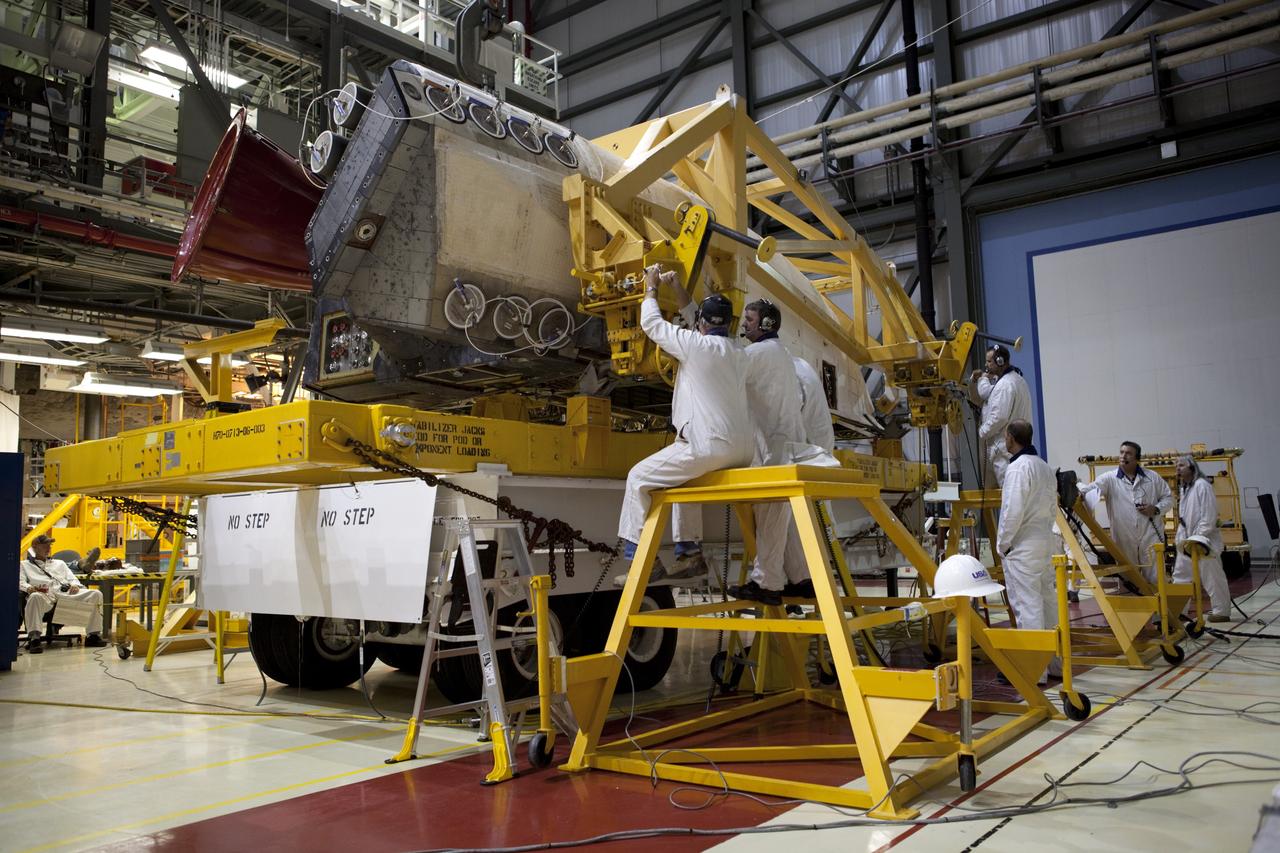 CAPE CANAVERAL, Fla. – Inside Orbiter Processing Facility-2 at NASA’s Kennedy Space Center in Florida, technicians help secure space shuttle Atlantis’ right orbital maneuvering system (OMS) pod onto a pallet.    The work is part of the Space Shuttle Program’s transition and retirement processing of shuttle Atlantis. Both OMS pods will be removed and sent to White Sands Space Harbor in New Mexico where they will undergo a complete deservicing and cleaning and then be returned to Kennedy for reinstallation on Atlantis. Atlantis is being prepared for display at the Kennedy Space Center Visitor Complex.  Photo credit: NASA/Dimitri Gerondidakis
