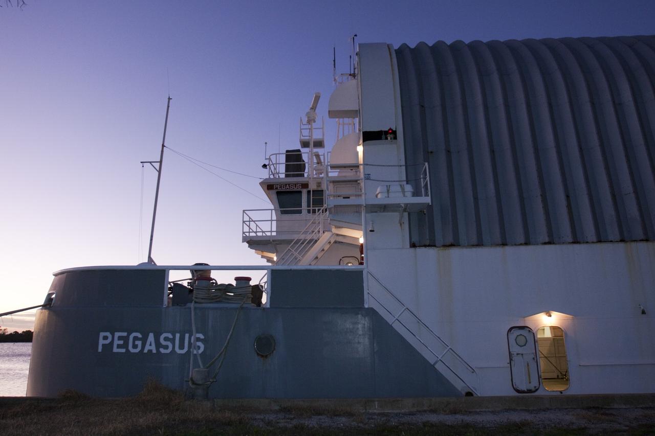 CAPE CANAVERAL, Fla. – The camera captures a side view of the Pegasus Barge which is moored in a secure area of the Turn Basin in the Launch Complex 39 area at NASA's Kennedy Space Center in Florida. The 266-foot-long and 50-foot-wide barge will be towed by NASA's Freedom Star ship to deliver space shuttle main engine (SSME) ground support equipment to Stennis Space Center near Bay St. Louis, Miss. Since being delivered to NASA in 1999, Pegasus sailed 41 times and transported 31 shuttle external fuel tanks from Michoud Assembly Facility near New Orleans to Kennedy. The barge will leave Kennedy, perhaps for the final time. Both the barge and shuttle equipment will remain in storage until their specific future uses are determined. The SSMEs themselves will be transported to Stennis separately for use with the agency’s new heavy-lift rocket, the Space Launch System. The work is part of the Space Shuttle Program’s transition and retirement processing. For more information about Shuttle Transition and Retirement, visit http://www.nasa.gov/mission_pages/transition/home/index.html. Photo credit: NASA/ Kim Shiflett