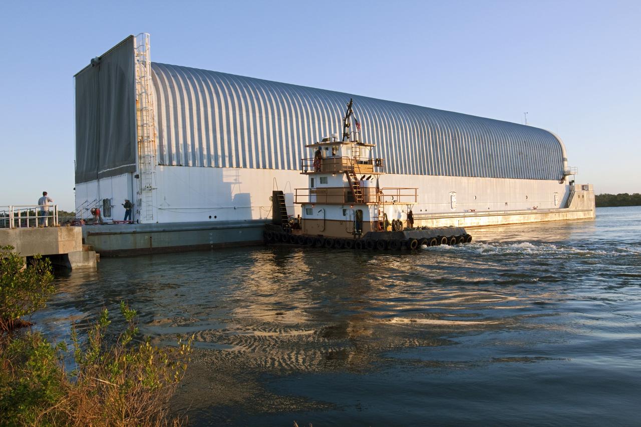CAPE CANAVERAL, Fla. – In the early morning light at the Turn Basin in the Launch Complex 39 area at NASA's Kennedy Space Center in Florida, a tugboat begins to position the Pegasus Barge for towing. The 266-foot-long and 50-foot-wide barge will be towed by NASA's Freedom Star ship to deliver space shuttle main engine (SSME) ground support equipment to Stennis Space Center near Bay St. Louis, Miss. Since being delivered to NASA in 1999, Pegasus sailed 41 times and transported 31 shuttle external fuel tanks from Michoud Assembly Facility near New Orleans to Kennedy. The barge will leave Kennedy, perhaps for the final time. Both the barge and shuttle equipment will remain in storage until their specific future uses are determined. The SSMEs themselves will be transported to Stennis separately for use with the agency’s new heavy-lift rocket, the Space Launch System. The work is part of the Space Shuttle Program’s transition and retirement processing. For more information about Shuttle Transition and Retirement, visit http://www.nasa.gov/mission_pages/transition/home/index.html. Photo credit: NASA/ Kim Shiflett