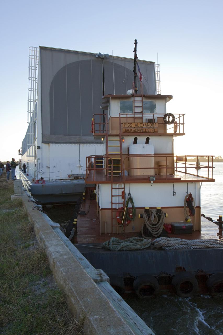 CAPE CANAVERAL, Fla. – At the Turn Basin in the Launch Complex 39 area at NASA's Kennedy Space Center in Florida, workers monitor nearby as the tugboat, Miss Alexandra, begins to position the Pegasus Barge for towing. The 266-foot-long and 50-foot-wide barge will be towed by NASA's Freedom Star ship to deliver space shuttle main engine (SSME) ground support equipment to Stennis Space Center near Bay St. Louis, Miss. Since being delivered to NASA in 1999, Pegasus sailed 41 times and transported 31 shuttle external fuel tanks from Michoud Assembly Facility near New Orleans to Kennedy. The barge will leave Kennedy, perhaps for the final time. Both the barge and shuttle equipment will remain in storage until their specific future uses are determined. The SSMEs themselves will be transported to Stennis separately for use with the agency’s new heavy-lift rocket, the Space Launch System. The work is part of the Space Shuttle Program’s transition and retirement processing. For more information about Shuttle Transition and Retirement, visit http://www.nasa.gov/mission_pages/transition/home/index.html. Photo credit: NASA/ Kim Shiflett