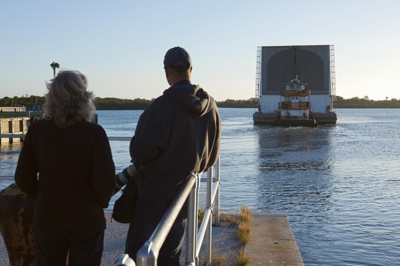CAPE CANAVERAL, Fla. – At the Turn Basin in the Launch Complex 39 area at NASA's Kennedy Space Center in Florida, workers look on as a tugboat pushes the Pegasus Barge away from the dock. The 266-foot-long and 50-foot-wide barge will be towed by NASA's Freedom Star ship to deliver space shuttle main engine (SSME) ground support equipment to Stennis Space Center near Bay St. Louis, Miss. Since being delivered to NASA in 1999, Pegasus sailed 41 times and transported 31 shuttle external fuel tanks from Michoud Assembly Facility near New Orleans to Kennedy. The barge is leaving Kennedy, perhaps for the final time. Both the barge and shuttle equipment will remain in storage until their specific future uses are determined. The SSMEs themselves will be transported to Stennis separately for use with the agency’s new heavy-lift rocket, the Space Launch System. The work is part of the Space Shuttle Program’s transition and retirement processing. For more information about Shuttle Transition and Retirement, visit http://www.nasa.gov/mission_pages/transition/home/index.html. Photo credit: NASA/ Kim Shiflett