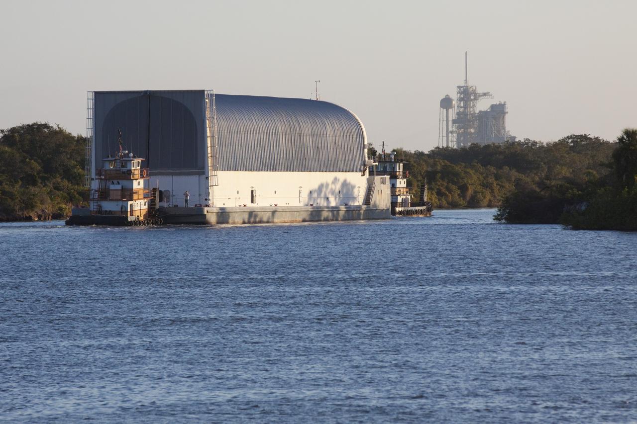 CAPE CANAVERAL, Fla. – Two tugboats move the Pegasus Barge through the Banana River near NASA's Kennedy Space Center in Florida. The 266-foot-long and 50-foot-wide barge will be towed by NASA's Freedom Star ship to deliver space shuttle main engine (SSME) ground support equipment to Stennis Space Center near Bay St. Louis, Miss. Since being delivered to NASA in 1999, Pegasus sailed 41 times and transported 31 shuttle external fuel tanks from Michoud Assembly Facility near New Orleans to Kennedy. To the right is Launch Pad 39A. The barge is leaving Kennedy, perhaps for the final time. Both the barge and shuttle equipment will remain in storage until their specific future uses are determined. The SSMEs themselves will be transported to Stennis separately for use with the agency’s new heavy-lift rocket, the Space Launch System. The work is part of the Space Shuttle Program’s transition and retirement processing. For more information about Shuttle Transition and Retirement, visit http://www.nasa.gov/mission_pages/transition/home/index.html. Photo credit: NASA/ Kim Shiflett