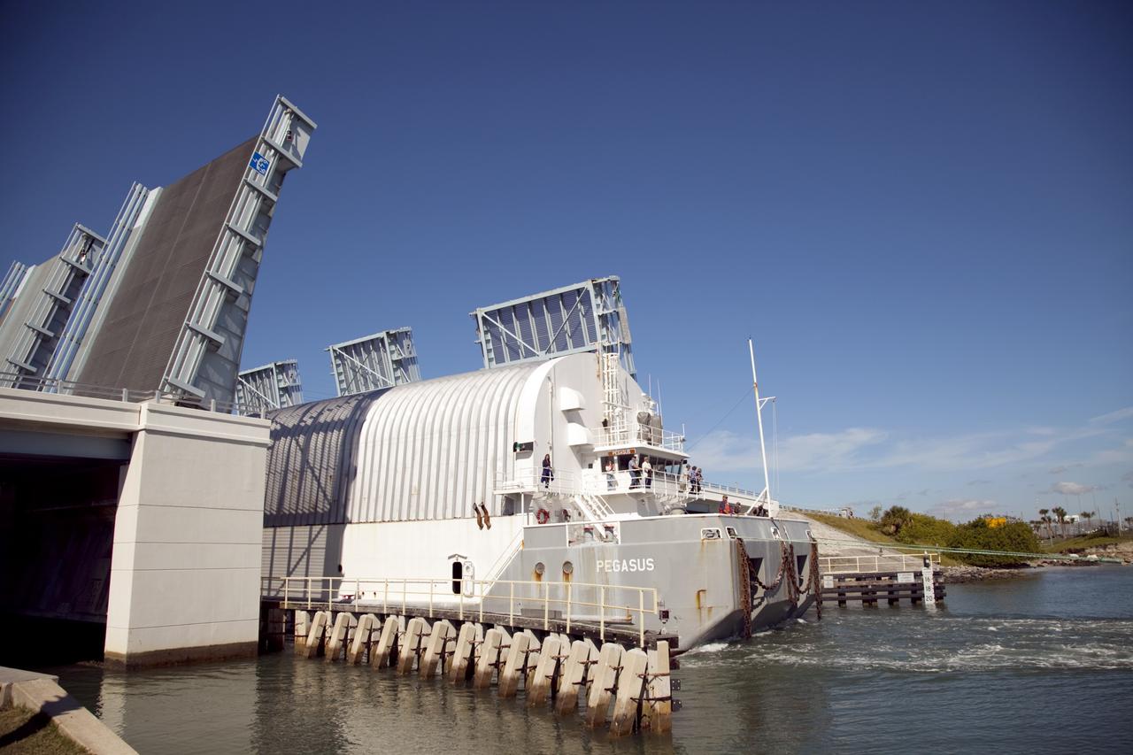 CAPE CANAVERAL, Fla. – The Pegasus Barge makes its way through a drawbridge after leaving NASA's Kennedy Space Center in Florida. The 266-foot-long and 50-foot-wide barge will be towed by NASA's Freedom Star ship to deliver space shuttle main engine (SSME) ground support equipment to Stennis Space Center near Bay St. Louis, Miss. Since being delivered to NASA in 1999, Pegasus sailed 41 times and transported 31 shuttle external fuel tanks from Michoud Assembly Facility near New Orleans to Kennedy. The barge is leaving Kennedy, perhaps for the final time. Both the barge and shuttle equipment will remain in storage until their specific future uses are determined. The SSMEs themselves will be transported to Stennis separately for use with the agency's new heavy-lift rocket, the Space Launch System. The work is part of the Space Shuttle Program’s transition and retirement processing. For more information about Shuttle Transition and Retirement, visit http://www.nasa.gov/mission_pages/transition/home/index.html. Photo credit: NASA/Frankie Martin