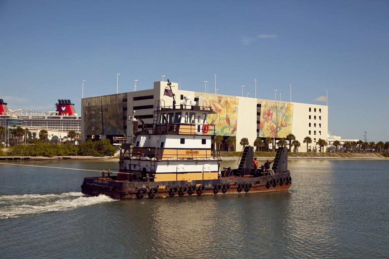 CAPE CANAVERAL, Fla. – A tugboat pulls the Pegasus Barge through Port Canaveral after leaving NASA's Kennedy Space Center in Florida. The 266-foot-long and 50-foot-wide barge will be towed by NASA's Freedom Star ship to deliver space shuttle main engine (SSME) ground support equipment to Stennis Space Center near Bay St. Louis, Miss. Since being delivered to NASA in 1999, Pegasus sailed 41 times and transported 31 shuttle external fuel tanks from Michoud Assembly Facility near New Orleans to Kennedy. The barge is leaving Kennedy, perhaps for the final time. Both the barge and shuttle equipment will remain in storage until their specific future uses are determined. The SSMEs themselves will be transported to Stennis separately for use with the agency's new heavy-lift rocket, the Space Launch System. The work is part of the Space Shuttle Program’s transition and retirement processing. For more information about Shuttle Transition and Retirement, visit http://www.nasa.gov/mission_pages/transition/home/index.html. Photo credit: NASA/Frankie Martin