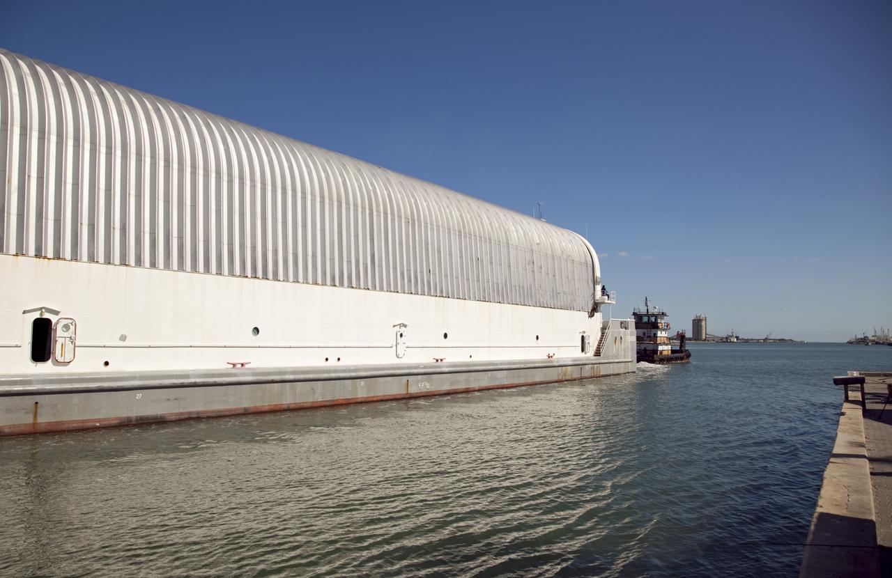 CAPE CANAVERAL, Fla. – A tugboat pulls the Pegasus Barge through Port Canaveral after leaving NASA's Kennedy Space Center in Florida. The 266-foot-long and 50-foot-wide barge will be towed by NASA's Freedom Star ship to deliver space shuttle main engine (SSME) ground support equipment to Stennis Space Center near Bay St. Louis, Miss. Since being delivered to NASA in 1999, Pegasus sailed 41 times and transported 31 shuttle external fuel tanks from Michoud Assembly Facility near New Orleans to Kennedy. The barge is leaving Kennedy, perhaps for the final time. Both the barge and shuttle equipment will remain in storage until their specific future uses are determined. The SSMEs themselves will be transported to Stennis separately for use with the agency's new heavy-lift rocket, the Space Launch System. The work is part of the Space Shuttle Program’s transition and retirement processing. For more information about Shuttle Transition and Retirement, visit http://www.nasa.gov/mission_pages/transition/home/index.html. Photo credit: NASA/Frankie Martin