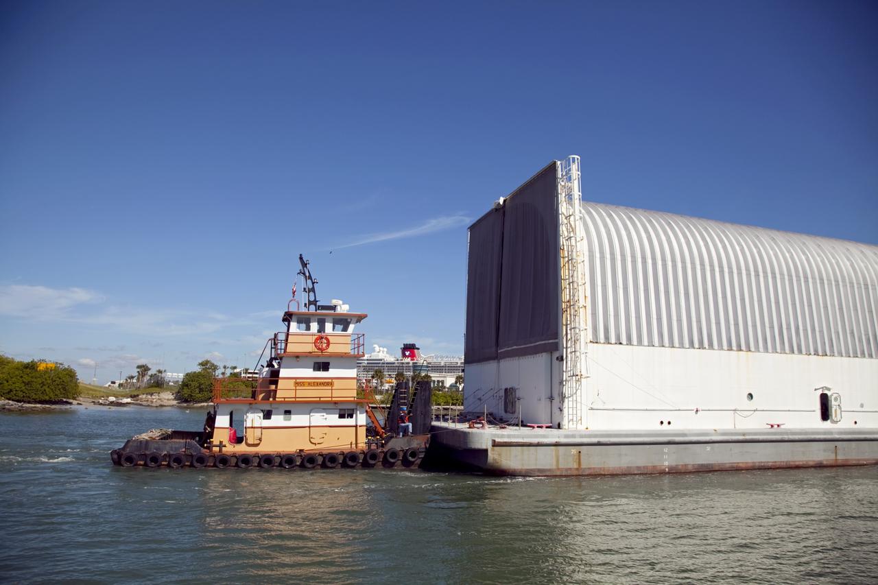 CAPE CANAVERAL, Fla. – A tugboat pulls the Pegasus Barge through Port Canaveral after leaving NASA's Kennedy Space Center in Florida. The 266-foot-long and 50-foot-wide barge will be towed by NASA's Freedom Star ship to deliver space shuttle main engine (SSME) ground support equipment to Stennis Space Center near Bay St. Louis, Miss. Since being delivered to NASA in 1999, Pegasus sailed 41 times and transported 31 shuttle external fuel tanks from Michoud Assembly Facility near New Orleans to Kennedy. The barge is leaving Kennedy, perhaps for the final time. Both the barge and shuttle equipment will remain in storage until their specific future uses are determined. The SSMEs themselves will be transported to Stennis separately for use with the agency's new heavy-lift rocket, the Space Launch System. The work is part of the Space Shuttle Program’s transition and retirement processing. For more information about Shuttle Transition and Retirement, visit http://www.nasa.gov/mission_pages/transition/home/index.html. Photo credit: NASA/Frankie Martin