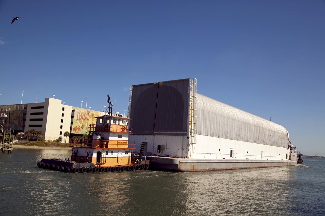 CAPE CANAVERAL, Fla. – A tugboat pushes the Pegasus Barge through Port Canaveral after leaving NASA's Kennedy Space Center in Florida. The 266-foot-long and 50-foot-wide barge will be towed by NASA's Freedom Star ship to deliver space shuttle main engine (SSME) ground support equipment to Stennis Space Center near Bay St. Louis, Miss. Since being delivered to NASA in 1999, Pegasus sailed 41 times and transported 31 shuttle external fuel tanks from Michoud Assembly Facility near New Orleans to Kennedy. The barge is leaving Kennedy, perhaps for the final time. Both the barge and shuttle equipment will remain in storage until their specific future uses are determined. The SSMEs themselves will be transported to Stennis separately for use with the agency's new heavy-lift rocket, the Space Launch System. The work is part of the Space Shuttle Program’s transition and retirement processing. For more information about Shuttle Transition and Retirement, visit http://www.nasa.gov/mission_pages/transition/home/index.html. Photo credit: NASA/Frankie Martin