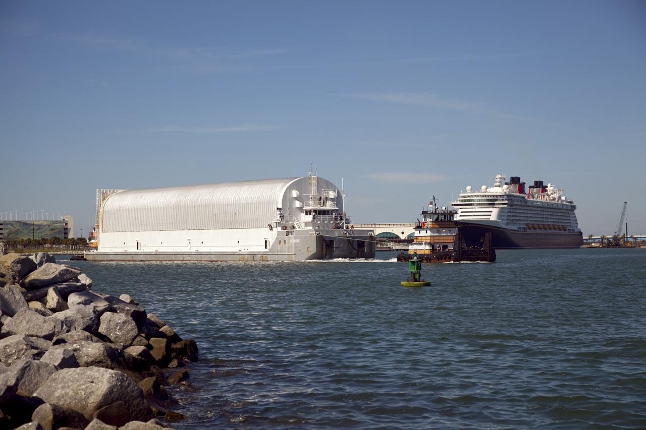 CAPE CANAVERAL, Fla. – A tugboat pulls the Pegasus Barge through Port Canaveral after leaving NASA's Kennedy Space Center in Florida. The 266-foot-long and 50-foot-wide barge will be towed by NASA's Freedom Star ship to deliver space shuttle main engine (SSME) ground support equipment to Stennis Space Center near Bay St. Louis, Miss. Since being delivered to NASA in 1999, Pegasus sailed 41 times and transported 31 shuttle external fuel tanks from Michoud Assembly Facility near New Orleans to Kennedy. The barge is leaving Kennedy, perhaps for the final time. Both the barge and shuttle equipment will remain in storage until their specific future uses are determined. The SSMEs themselves will be transported to Stennis separately for use with the agency's new heavy-lift rocket, the Space Launch System. The work is part of the Space Shuttle Program’s transition and retirement processing. For more information about Shuttle Transition and Retirement, visit http://www.nasa.gov/mission_pages/transition/home/index.html. Photo credit: NASA/Frankie Martin