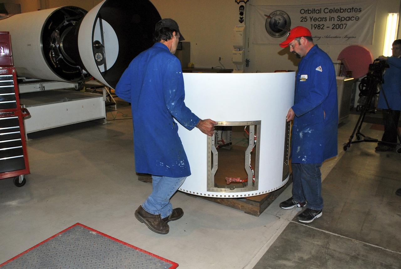 VANDENBERG AIR FORCE BASE, Calif. -- At a Pegasus booster processing facility at Vandenberg Air Force Base in California, technicians prepare a section of the aft skirt for installation on the Pegasus XL rocket's (seen to the left) first stage.      The Orbital Sciences Corp. Pegasus rocket will launch the Nuclear Spectroscopic Telescope Array (NuSTAR) into space. After the rocket and spacecraft are processed at Vandenberg, they will be flown on the Orbital Sciences’ L-1011 carrier aircraft to the Ronald Reagan Ballistic Missile Defense Test Site at the Pacific Ocean’s Kwajalein Atoll for launch. The high-energy x-ray telescope will conduct a census for black holes, map radioactive material in young supernovae remnants, and study the origins of cosmic rays and the extreme physics around collapsed stars. For more information, visit science.nasa.gov/missions/nustar/. Photo credit: NASA/Randy Beaudoin, VAFB