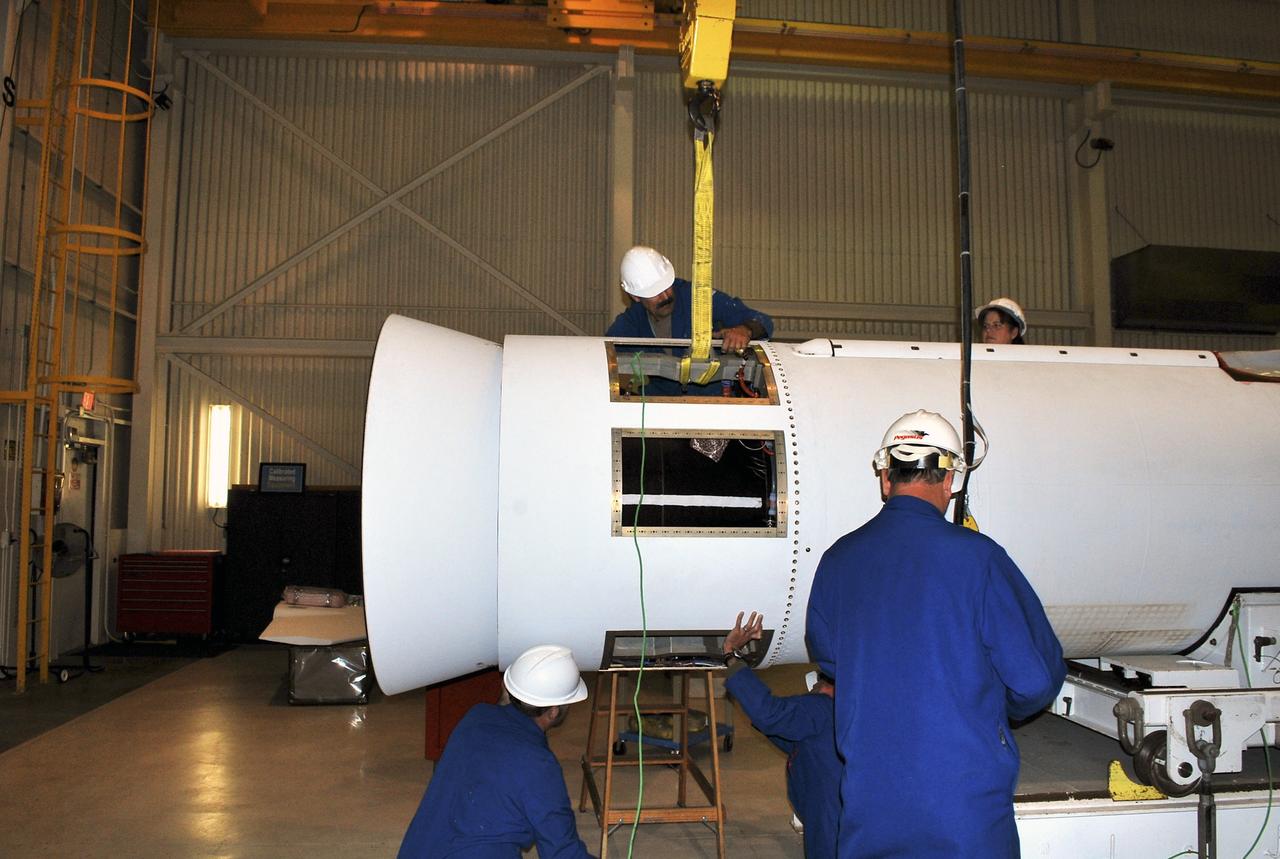 VANDENBERG AIR FORCE BASE, Calif. -- At a Pegasus booster processing facility at Vandenberg Air Force Base in California, using a crane, technicians install a section of the aft skirt on the Pegasus XL rocket’s first stage.     The Orbital Sciences Corp. Pegasus rocket will launch the Nuclear Spectroscopic Telescope Array (NuSTAR) into space. After the rocket and spacecraft are processed at Vandenberg, they will be flown on the Orbital Sciences’ L-1011 carrier aircraft to the Ronald Reagan Ballistic Missile Defense Test Site at the Pacific Ocean’s Kwajalein Atoll for launch. The high-energy x-ray telescope will conduct a census for black holes, map radioactive material in young supernovae remnants, and study the origins of cosmic rays and the extreme physics around collapsed stars. For more information, visit science.nasa.gov/missions/nustar/. Photo credit: NASA/Randy Beaudoin, VAFB