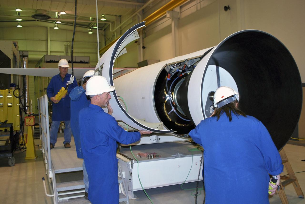 VANDENBERG AIR FORCE BASE, Calif. -- At a Pegasus booster processing facility at Vandenberg Air Force Base in California, using a crane, technicians install the second section of the aft skirt on the Pegasus XL rocket’s first stage.     The Orbital Sciences Corp. Pegasus rocket will launch the Nuclear Spectroscopic Telescope Array (NuSTAR) into space. After the rocket and spacecraft are processed at Vandenberg, they will be flown on the Orbital Sciences’ L-1011 carrier aircraft to the Ronald Reagan Ballistic Missile Defense Test Site at the Pacific Ocean’s Kwajalein Atoll for launch. The high-energy x-ray telescope will conduct a census for black holes, map radioactive material in young supernovae remnants, and study the origins of cosmic rays and the extreme physics around collapsed stars. For more information, visit science.nasa.gov/missions/nustar/. Photo credit: NASA/Randy Beaudoin, VAFB