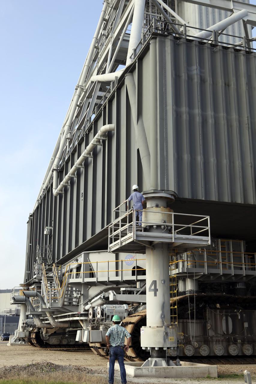 CAPE CANAVERAL, Fla. – At NASA’s Kennedy Space Center in Florida, the camera captures a unique view of the crawler-transporter as it is prepared to move the mobile launcher (ML) from next to Kennedy's Vehicle Assembly Building to Launch Pad 39B, a distance of 4.2 miles. Data on the ML will be collected from structural and functional engineering tests and used for the next phases of construction. The 355-foot-tall ML structure, which took about two years to construct, is being modified to support NASA’s Space Launch System (SLS), the heavy-lift rocket that will launch astronauts farther into space than ever before. SLS will also create high-quality jobs here at home, and provide the cornerstone for America's future human space exploration efforts. Photo credit: NASA/Dimitri Gerondidakis