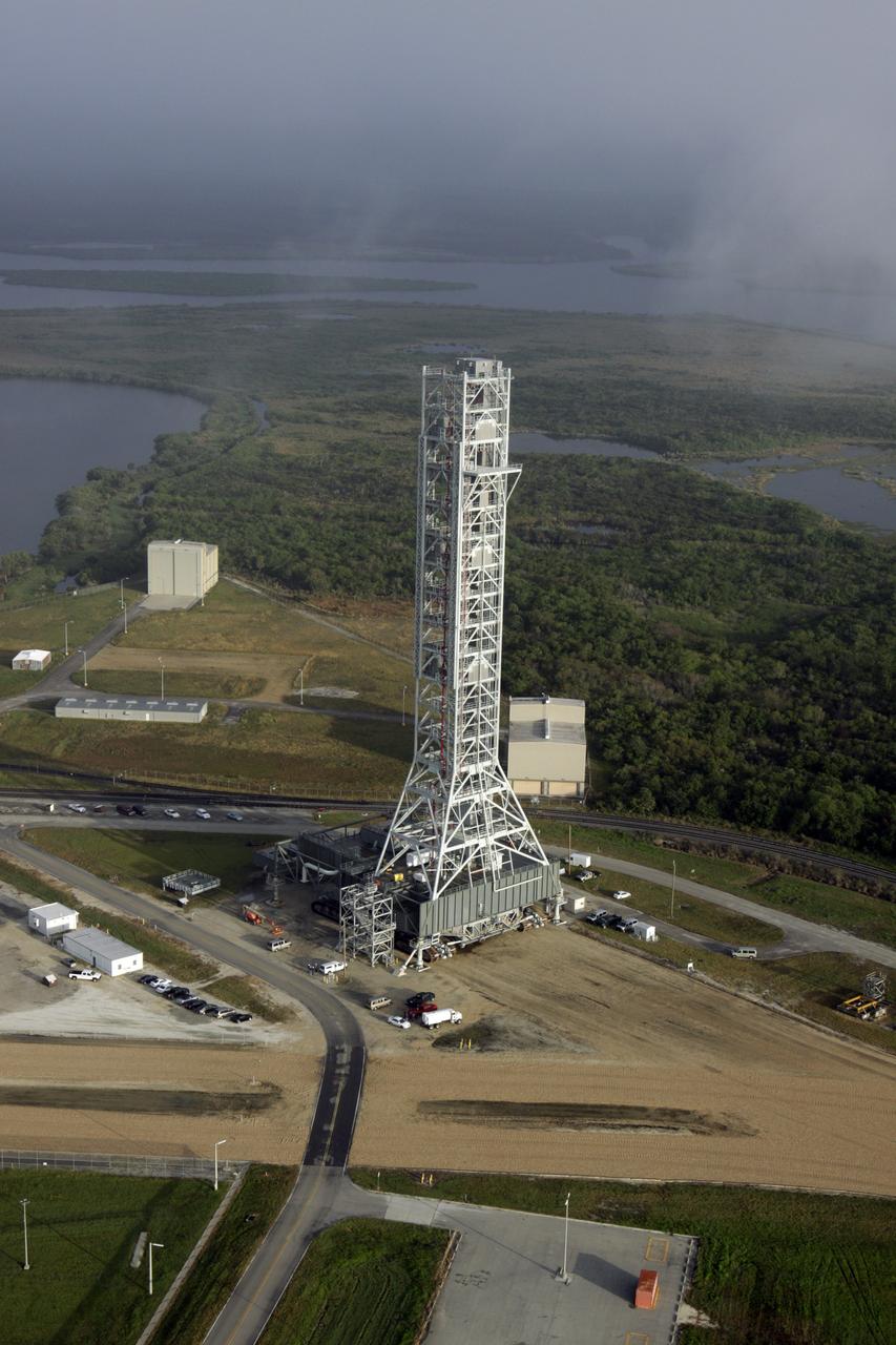 CAPE CANAVERAL, Fla. – At NASA's Kennedy Space Center in Florida, this aerial view taken from atop the Vehicle Assembly Building shows the mobile launcher (ML) as it begins its move aboard a crawler-transporter from next to Kennedy's Vehicle Assembly Building to Launch Pad 39B, a distance of 4.2 miles. Data on the ML will be collected from structural and functional engineering tests and used for the next phases of construction. The 355-foot-tall ML structure, which took about two years to construct, is being modified to support NASA’s Space Launch System (SLS), the heavy-lift rocket that will launch astronauts farther into space than ever before. SLS will also create high-quality jobs here at home, and provide the cornerstone for America's future human space exploration efforts. Photo credit: NASA/Kim Shiflett