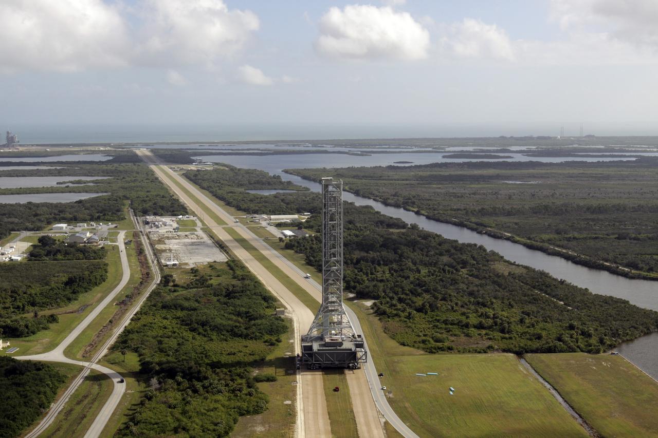 CAPE CANAVERAL, Fla. – On the crawlerway at NASA's Kennedy Space Center in Florida, an aerial view shows the mobile launcher (ML) as it rolls out aboard the crawler-transporter moving from next to Kennedy's Vehicle Assembly Building to Launch Pad 39B, a distance of 4.2 miles. Data on the ML will be collected from structural and functional engineering tests and used for the next phases of construction. The 355-foot-tall ML structure, which took about two years to construct, is being modified to support NASA’s Space Launch System (SLS), the heavy-lift rocket that will launch astronauts farther into space than ever before. SLS will also create high-quality jobs here at home, and provide the cornerstone for America's future human space exploration efforts. Photo credit: NASA/Kim Shiflett