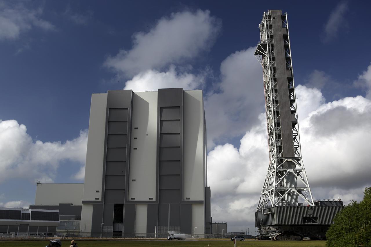 CAPE CANAVERAL, Fla. – At NASA’s Kennedy Space Center in Florida, a water truck leads the way spraying water on the dry crawlerway to reduce dust particles in the air, as the mobile launcher (ML) begins its move aboard a crawler-transporter. The ML is moving from next to Kennedy's Vehicle Assembly Building to Launch Pad 39B, a distance of 4.2 miles. Data on the ML will be collected from structural and functional engineering tests and used for the next phases of construction. The 355-foot-tall ML structure, which took about two years to construct, is being modified to support NASA’s Space Launch System (SLS), the heavy-lift rocket that will launch astronauts farther into space than ever before. SLS will also create high-quality jobs here at home, and provide the cornerstone for America's future human space exploration efforts. Photo credit: NASA/Dimitri Gerondidakis
