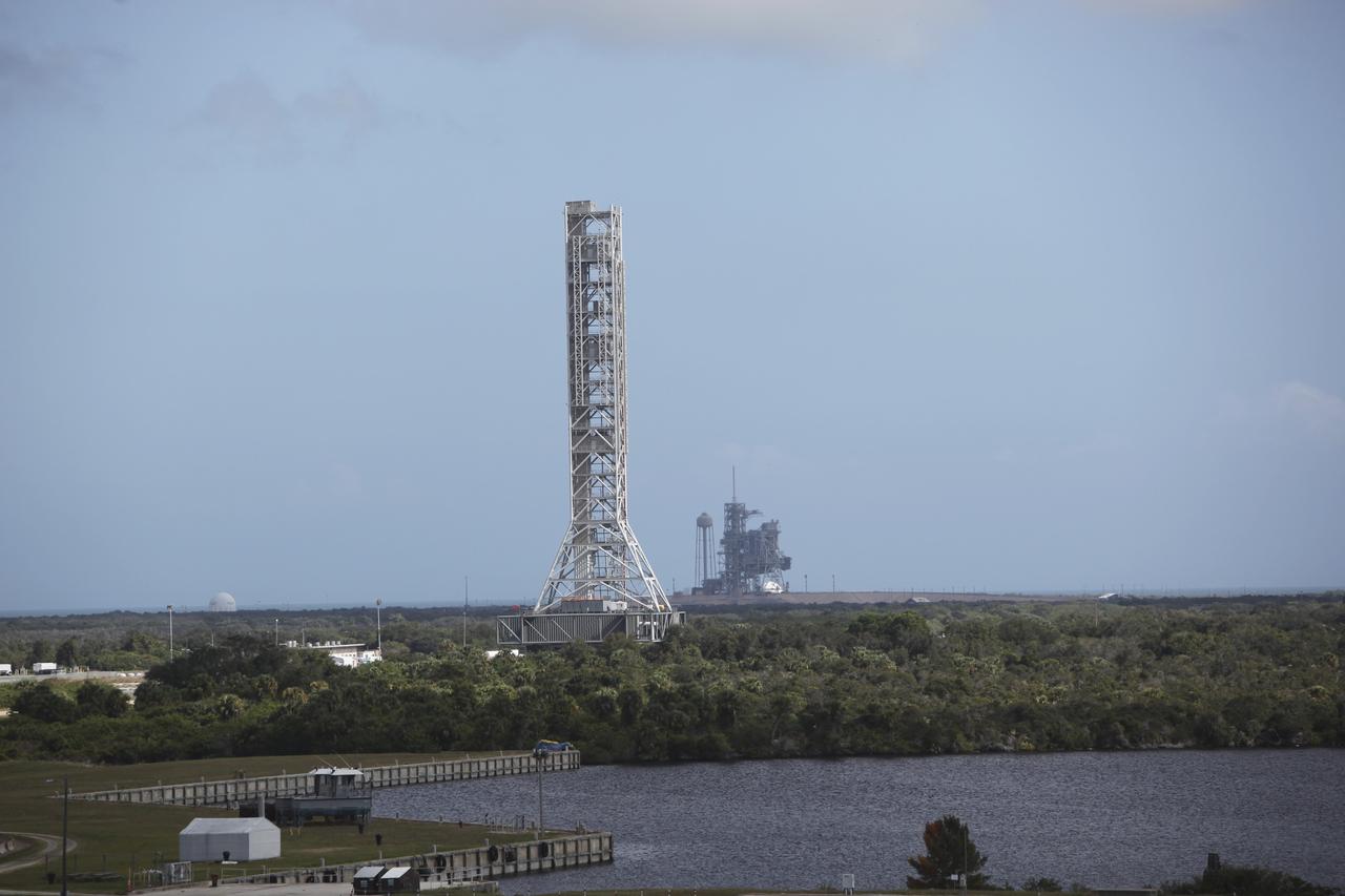 CAPE CANAVERAL, Fla. – At NASA's Kennedy Space Center in Florida, an aerial view shows the mobile launcher (ML) as it rolls out aboard the crawler-transporter moving from next to Kennedy's Vehicle Assembly Building to Launch Pad 39B, a distance of 4.2 miles. Data on the ML will be collected from structural and functional engineering tests and used for the next phases of construction. In the distance is Launch Pad 39A. The 355-foot-tall ML structure, which took about two years to construct, is being modified to support NASA’s Space Launch System (SLS), the heavy-lift rocket that will launch astronauts farther into space than ever before. SLS will also create high-quality jobs here at home, and provide the cornerstone for America's future human space exploration efforts. Photo credit: NASA/Dimitri Gerondidakis