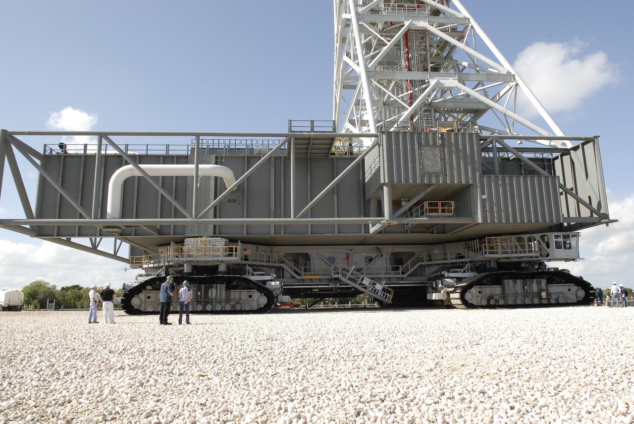 CAPE CANAVERAL, Fla. – On the crawlerway at NASA’s Kennedy Space Center in Florida, technicians confer before the crawler-transporter as it rolls out the mobile launcher (ML) from next to Kennedy's Vehicle Assembly Building to Launch Pad 39B, a distance of 4.2 miles. Rollout began at about 9:15 a.m. EST. Data on the ML will be collected from structural and functional engineering tests and used for the next phases of construction overseen by NASA’s 21st Century Ground Systems Program. The 355-foot-tall ML structure, which took about two years to construct, is being modified to support NASA’s Space Launch System (SLS), the heavy-lift rocket that will launch astronauts farther into space than ever before. SLS will also create high-quality jobs here at home, and provide the cornerstone for America's future human space exploration efforts. Photo credit: NASA/Charisse Nahser