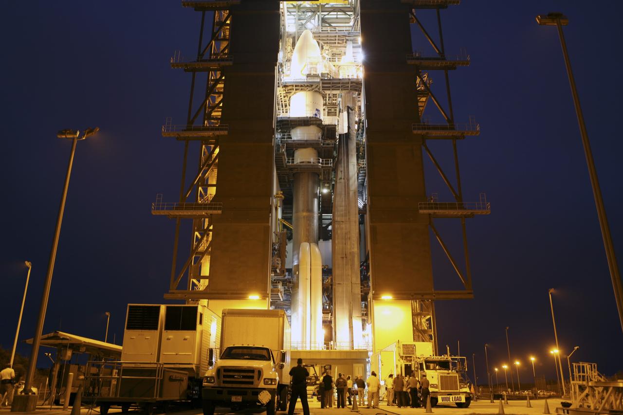 CAPE CANAVERAL, Fla. -- The Atlas V rocket set to launch NASA's Mars Science Laboratory (MSL) mission is illuminated inside the Vertical Integration Facility at Space Launch Complex 41, where employees have gathered to hoist the spacecraft's multi-mission radioisotope thermoelectric generator (MMRTG). The MMRTG will be lifted up to the top of the rocket and installed on the MSL spacecraft, encapsulated within the payload fairing.    The MMRTG will generate the power needed for the mission from the natural decay of plutonium-238, a non-weapons-grade form of the radioisotope. Heat emitted by this natural decay will provide constant power through the day and night during all seasons. MSL's components include a car-sized rover, Curiosity, which has 10 science instruments designed to search for signs of life, including methane, and help determine if the gas is from a biological or geological source. Heat emitted by the MMRTG will be circulated throughout the rover system to keep instruments, computers, mechanical devices and communications systems within their operating temperature ranges. Launch of MSL aboard a United Launch Alliance Atlas V rocket is targeted for Nov. 25 from Space Launch Complex 41 on Cape Canaveral Air Force Station. For more information, visit http://www.nasa.gov/msl. Photo credit: NASA/Dimitri Gerondidakis