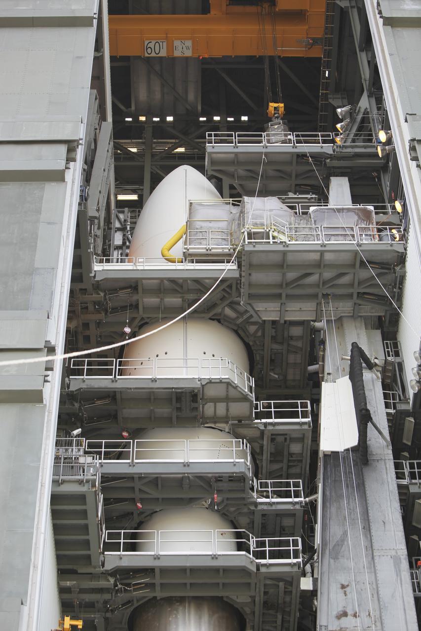 CAPE CANAVERAL, Fla. -- The "gorilla cage," holding the multi-mission radioisotope thermoelectric generator (MMRTG) for NASA's Mars Science Laboratory (MSL) mission, is settled on one of the upper levels above the Atlas V rocket in the Vertical Integration Facility at Space Launch Complex 41. The MMRTG will be installed on the MSL spacecraft, encapsulated within the payload fairing.    The MMRTG will generate the power needed for the mission from the natural decay of plutonium-238, a non-weapons-grade form of the radioisotope. Heat emitted by this natural decay will provide constant power through the day and night during all seasons. MSL's components include a car-sized rover, Curiosity, which has 10 science instruments designed to search for signs of life, including methane, and help determine if the gas is from a biological or geological source. Heat emitted by the MMRTG will be circulated throughout the rover system to keep instruments, computers, mechanical devices and communications systems within their operating temperature ranges. Launch of MSL aboard a United Launch Alliance Atlas V rocket is targeted for Nov. 25 from Space Launch Complex 41 on Cape Canaveral Air Force Station. For more information, visit http://www.nasa.gov/msl. Photo credit: NASA/Dimitri Gerondidakis