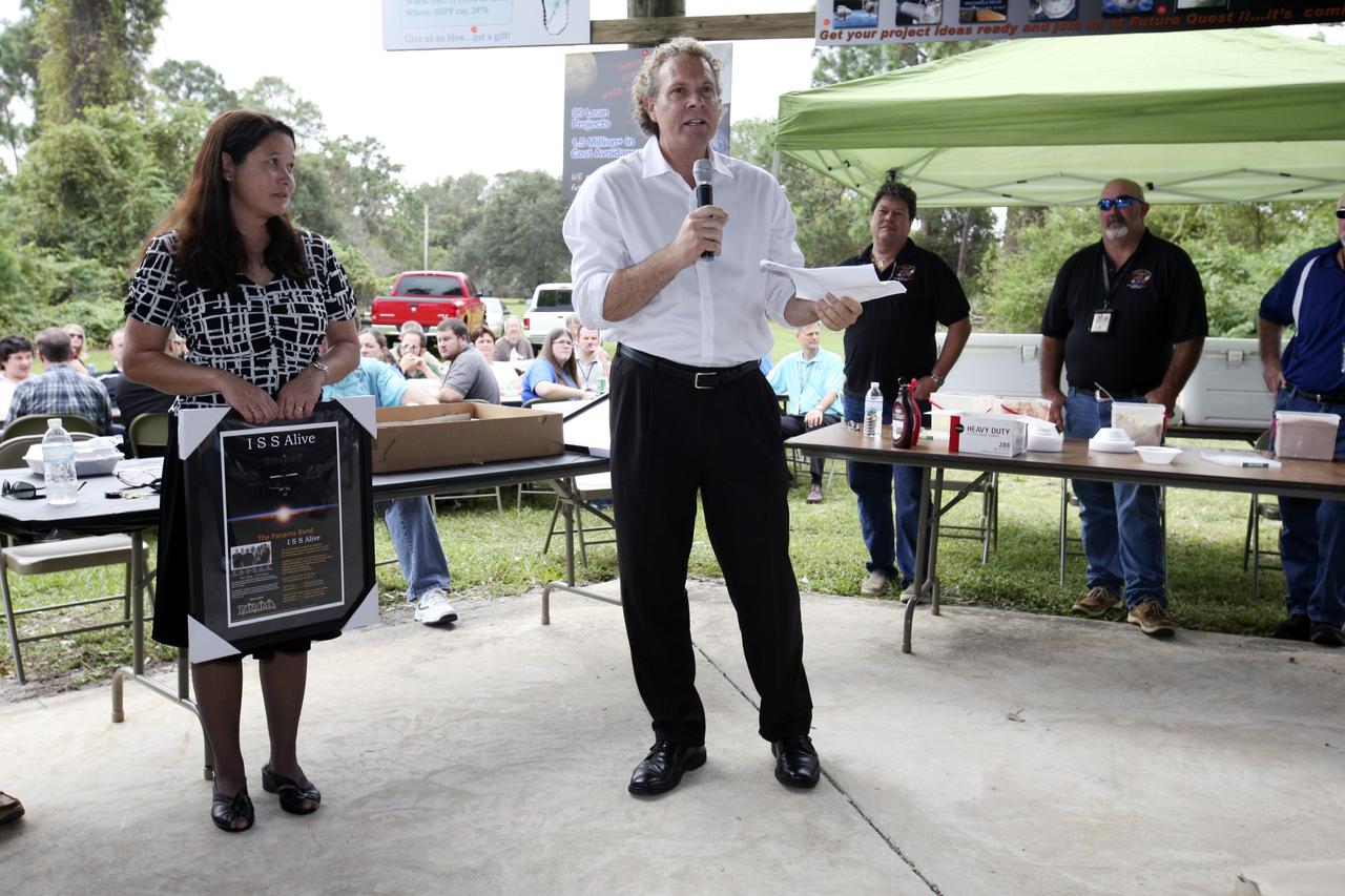 CAPE CANAVERAL, Fla. – Associate Director for Engineering and Technical Operations Russell Romanella talks to International Space Station employees based at NASA's Kennedy Space Center in Florida during the "ISS Is Alive" employee recognition barbecue celebration at Kars Park II while International Space Station Ground Processing and Research Project Office Director Josie Burnett, left, looks on. NASA and The Boeing Co. hosted the celebration to thank the employees based at the Kennedy Space Center who were involved in building the largest, most complex international scientific project in history and the largest venture in space to date.    The station has hosted human life, work and research in space for more than 10 years. Boeing is the prime contractor to NASA for the space station. In addition to designing and building all the major U.S. elements, Boeing also is responsible for ensuring the successful integration of new hardware and software -- including components from international partners -- as well as for providing sustaining engineering work. For more information on the International Space Station, visit http://www.nasa.gov/station.  Photo credit: NASA/Amanda Diller
