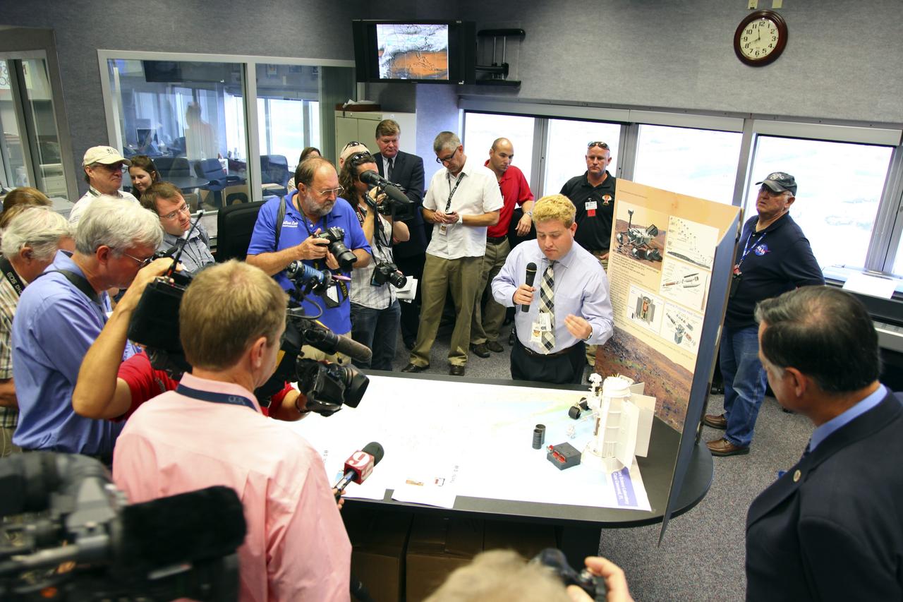 CAPE CANAVERAL, Fla. -- During a tour of the Radiological Control Center (RADCC) at NASA's Kennedy Space Center in Florida, members of the media listen as Ryan Bechtel of the U.S. Department of Energy explains safety equipment and procedures for the upcoming launch of the Mars Science Laboratory (MSL) mission.    The MSL spacecraft includes a multi-mission radioisotope thermoelectric generator (MMRTG) that will generate the power needed for the mission from the natural decay of plutonium-238, a non-weapons-grade form of the radioisotope. MSL's components include a car-sized rover, Curiosity, which has 10 science instruments designed to search for signs of life, including methane, and help determine if the gas is from a biological or geological source. Launch of MSL aboard a United Launch Alliance Atlas V rocket is targeted for Nov. 26 from Space Launch Complex 41 on Cape Canaveral Air Force Station. For more information, visit http://www.nasa.gov/msl. Photo credit: NASA/Frankie Martin