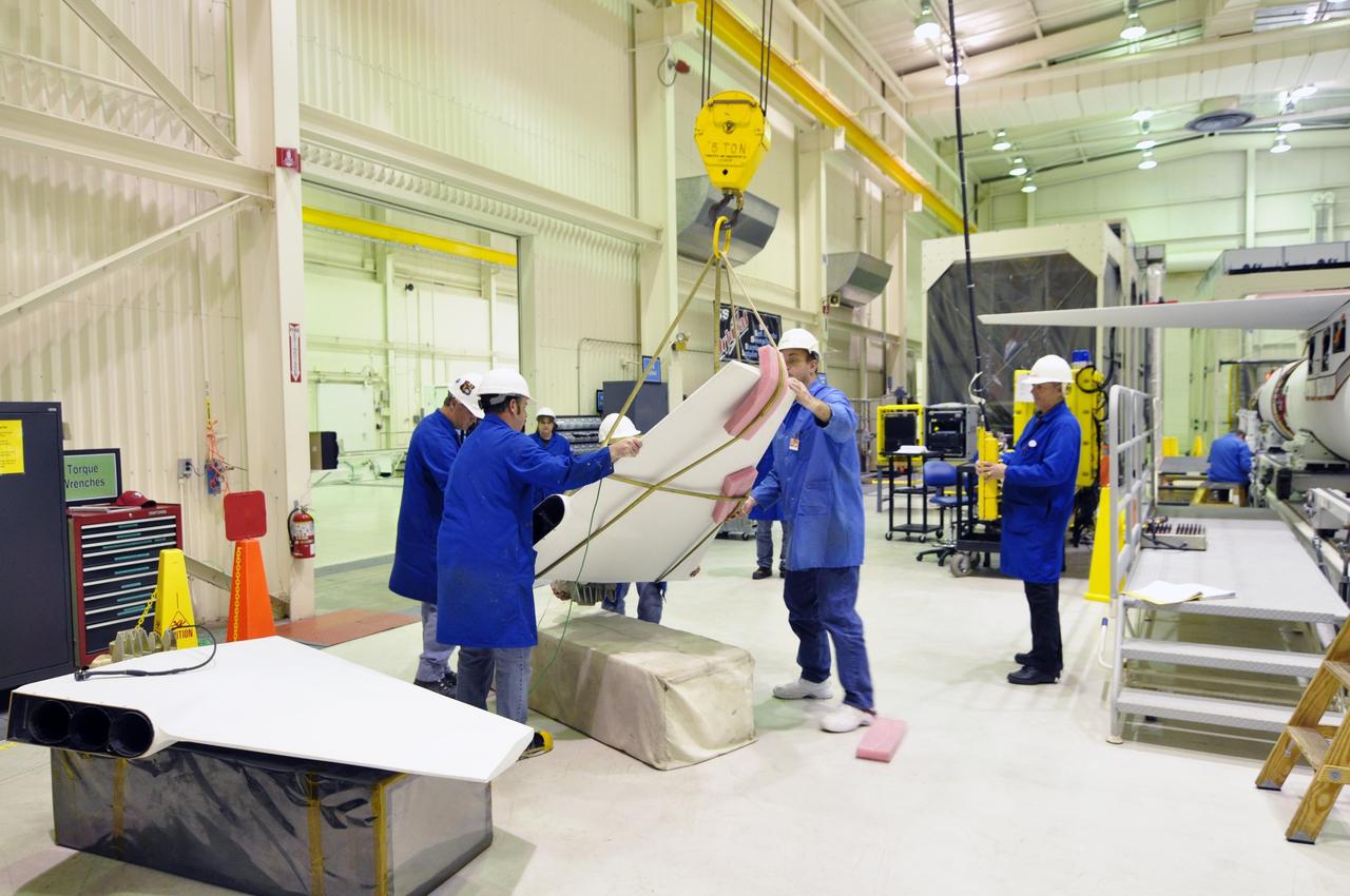 VANDENBERG AIR FORCE BASE, Calif. -- Inside a Pegasus booster processing facility at Vandenberg Air Force Base in California, an overhead crane lifts the first of three fins for the aft end of the Pegasus XL rocket's first stage as technicians prepare to install it.            The Orbital Sciences Corp. Pegasus rocket will launch the Nuclear Spectroscopic Telescope Array (NuSTAR) into space. After the rocket and spacecraft are processed at Vandenberg, they will be flown on the Orbital Sciences’ L-1011 carrier aircraft to the Ronald Reagan Ballistic Missile Defense Test Site at the Pacific Ocean’s Kwajalein Atoll for launch. The high-energy x-ray telescope will conduct a census for black holes, map radioactive material in young supernovae remnants, and study the origins of cosmic rays and the extreme physics around collapsed stars. For more information, visit science.nasa.gov/missions/nustar/. Photo credit: NASA/Randy Beaudoin, VAFB