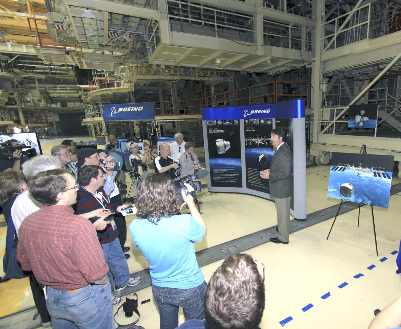 CAPE CANAVERAL, Fla. -- Chuck Hardison, the production and ground operations manager of The Boeing Co.'s Commercial Crew Transportation System, talks to media about plans to take NASA astronauts to the International Space Station in Orbiter Processing Facility-3 (OPF-3) at NASA's Kennedy Space Center in Florida. Boeing is maturing its CST-100 spacecraft design for NASA's Commercial Crew Program (CCP) under the Commercial Crew Development Round 2 (CCDev2) activities. Boeing's current design shows the CST-100 taking up to seven astronauts and cargo to the space station or other low Earth orbit destinations by the middle of the decade. Through an agreement with NASA and Space Florida, Boeing is leasing OPF-3, the Processing Control Facility (PCC) and Space Shuttle Main Engine Shop at Kennedy to design, manufacture, process and integrate the CST-100. This work is expected to generate up to 550 engineering and technical jobs for Florida's Space Coast. Hardison explained that the CST-100 will be manufactured using a spin-form technology, which is expected to bring down the cost and safety concerns of a traditional welded spacecraft. It's innovations such as this that CCP hopes will drive down the cost of space travel as well as open up space to more people than ever before.       Seven aerospace companies are maturing launch vehicle and spacecraft designs under CCDev2, including Alliant Techsystems Inc. (ATK) of Promontory, Utah, Blue Origin of Kent, Wash., The Boeing Co., of Houston, Excalibur Almaz Inc. of Houston, Sierra Nevada Corp. of Louisville, Colo., Space Exploration Technologies (SpaceX) of Hawthorne, Calif., and United Launch Alliance (ULA) of Centennial, Colo. For more information, visit www.nasa.gov/exploration/commercial Photo credit: Jim Grossmann