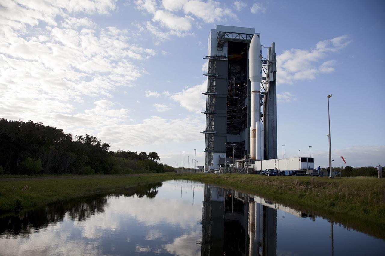 CAPE CANAVERAL, Fla. -- At Space Launch Complex 41 on Cape Canaveral Air Force Station in Florida, a pond reflects the 197-foot-tall United Launch Alliance Atlas V rocket and Vertical Integration Facility (VIF) against a blue sky flecked with white clouds. Atop the rocket is NASA's Mars Science Laboratory (MSL), enclosed in its payload fairing. The rocket began its move from the VIF to the launch pad at 8 a.m. EST, reaching the pad at 8:40 a.m.    Liftoff is planned during a launch window which extends from 10:02 a.m. to 11:45 a.m. EST on Nov. 26. MSL's components include a car-sized rover, Curiosity, which has 10 science instruments designed to search for signs of life, including methane, and help determine if the gas is from a biological or geological source. For more information, visit http://www.nasa.gov/msl. Photo credit: NASA/Frankie Martin