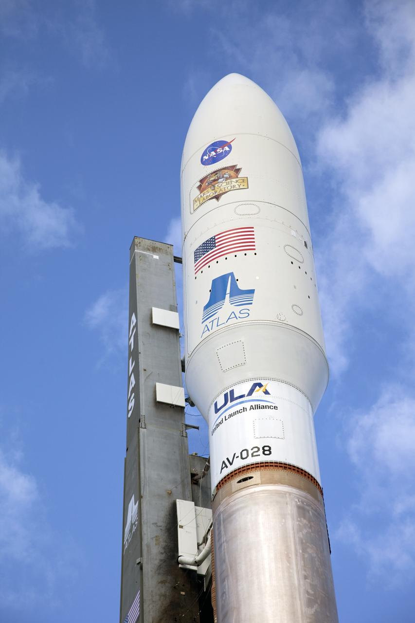 CAPE CANAVERAL, Fla. -- The NASA and Mars Science Laboratory (MSL) logos appear above the American flag and Atlas logo on the payload fairing atop the 197-foot-tall United Launch Alliance Atlas V rocket. Enclosed inside the fairing is the MSL spacecraft, awaiting its launch on a mission to the Red Planet. The rocket is on its way from the Vertical Integration Facility to the launch pad at Space Launch Complex 41 on Cape Canaveral Air Force Station in Florida. The vehicle arrived at the launch pad at 8:40 a.m. EST. Liftoff is planned during a launch window which extends from 10:02 a.m. to 11:45 a.m. EST on Nov. 26. MSL's components include a car-sized rover, Curiosity, which has 10 science instruments designed to search for signs of life, including methane, and help determine if the gas is from a biological or geological source. For more information, visit http://www.nasa.gov/msl. Photo credit: NASA/Frankie Martin