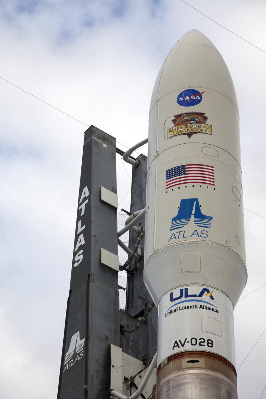 CAPE CANAVERAL, Fla. -- The NASA and Mars Science Laboratory (MSL) logos appear above the American flag and Atlas logo on the payload fairing atop the 197-foot-tall United Launch Alliance Atlas V rocket. Enclosed inside the fairing is the MSL spacecraft, awaiting its launch on a mission to the Red Planet. At 8 a.m., the rocket rolled out of the Vertical Integration Facility at Space Launch Complex 41 on Cape Canaveral Air Force Station in Florida, arriving at the launch pad at 8:40 a.m. Liftoff is planned during a launch window which extends from 10:02 a.m. to 11:45 a.m. EST on Nov. 26. MSL's components include a car-sized rover, Curiosity, which has 10 science instruments designed to search for signs of life, including methane, and help determine if the gas is from a biological or geological source. For more information, visit http://www.nasa.gov/msl. Photo credit: NASA/Frankie Martin