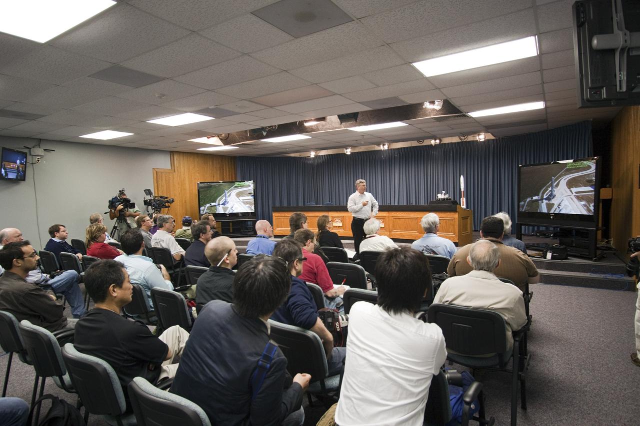 CAPE CANAVERAL, Fla. – In NASA Kennedy Space Center's Press Site auditorium in Florida, Scott Colloredo, NASA 21st Century Ground Systems project manager, gives the media representatives who will be taking the 21st Century Ground Systems tour an overview of the locations they will be visiting, including the Vehicle Assembly Building, a crawler-transporter parked on the crawlerway, the new mobile launcher on Launch Pad 39B, and the Launch Control Center's Firing Room 1. These facilities and equipment will be used to prepare and launch NASA's new Orion spacecraft on the Space Launch System heavy-lift rocket. The tour was arranged as part of prelaunch media activities for the agency's Mars Science Laboratory (MSL) launch. Liftoff of MSL aboard a United Launch Alliance Atlas V rocket from Space Launch Complex-41 on Cape Canaveral Air Force Station is planned during a launch window which extends from 10:02 a.m. to 11:45 a.m. EST on Nov. 26. For more information, visit http://www.nasa.gov/msl. Photo credit: NASA/Jim Grossmann