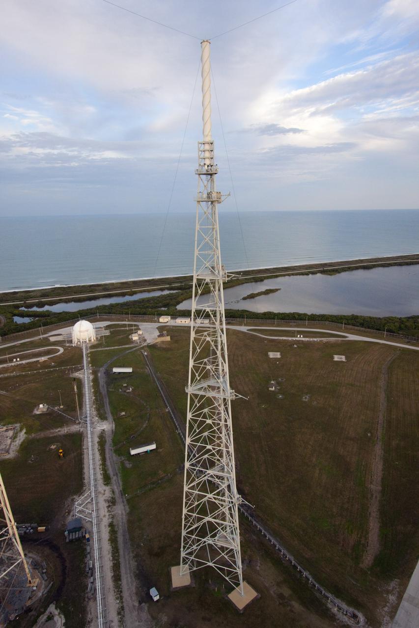 CAPE CANAVERAL, Fla. – At NASA Kennedy Space Center in Florida, this view, taken from the top of the 355-foot-tall mobile launcher at Launch Pad 39B, illustrates the close proximity of the pad to the Atlantic Ocean in the background. The structure in the center of the photo is one of three lightning masts at the pad. Media representatives are taking the 21st Century Ground Systems tour which also includes the Vehicle Assembly Building, a crawler-transporter parked on the crawlerway, and the Launch Control Center's Firing Room 1. These facilities and equipment will be used to prepare and launch NASA's new Orion spacecraft on the Space Launch System heavy-lift rocket. The tour was arranged as part of prelaunch media activities for the agency's Mars Science Laboratory (MSL) launch. Liftoff of MSL aboard a United Launch Alliance Atlas V rocket from Space Launch Complex-41 on Cape Canaveral Air Force Station is planned during a launch window which extends from 10:02 a.m. to 11:45 a.m. EST on Nov. 26. For more information, visit http://www.nasa.gov/msl. Photo credit: NASA/Jim Grossmann