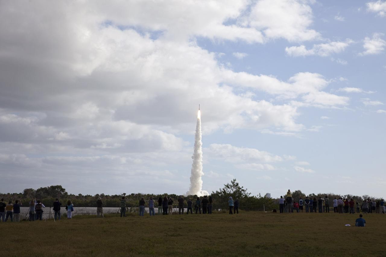 CAPE CANAVERAL, Fla. – At NASA Kennedy Space Center's Press Site in Florida, participants in NASA's Tweetup photograph the launch of the agency's Mars Science Laboratory (MSL) from the turn basin. The tweeters will share their experiences with followers through the social networking site Twitter. The 197-foot-tall United Launch Alliance Atlas V rocket lifted off Space Launch Complex-41 on neighboring Cape Canaveral Air Force Station at 10:02 a.m. EST at the opening of the launch window. MSL's components include a car-sized rover, Curiosity, which has 10 science instruments designed to search for signs of life, including methane, and help determine if the gas is from a biological or geological source. For more information, visit http://www.nasa.gov/msl. Photo credit: NASA/Frankie Martin