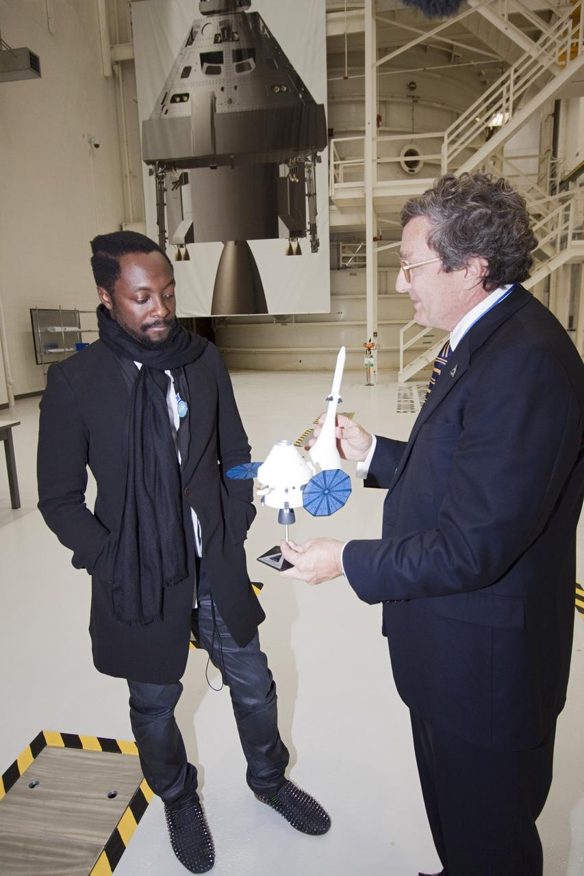 CAPE CANAVERAL, Fla. – At NASA Kennedy Space Center in Florida, Will.i.am (left), entertainer and member of The Black Eyed Peas, receives a briefing from Larry Price, Lockheed Martin deputy program manager, on the Orion Multi Purpose Crew Vehicle and the Space Launch System heavy-lift rocket during a tour of the Operations and Checkout Building (O&C).  The visit to the O&C followed Will.i.am's participation in a NASA Tweetup.     The Tweetup is part of prelaunch activities for the agency’s Mars Science Laboratory (MSL) launch and provides the opportunity for tweeters will share their experiences with followers through the social networking site Twitter. The MSL mission will pioneer precision landing technology and a sky-crane touchdown to place a car-sized rover, Curiosity, near the foot of a mountain inside Gale Crater on Aug. 6, 2012. During a nearly two-year prime mission after landing, the rover will investigate whether the region has ever offered conditions favorable for microbial life, including the chemical ingredients for life.  Liftoff of MSL aboard a United Launch Alliance Atlas V rocket from Space Launch Complex-41 on Cape Canaveral Air Force Station was at 10:02 a.m. EST on Nov. 26. For more information, visit http://www.nasa.gov/msl. Photo credit: NASA/Jim Grossmann