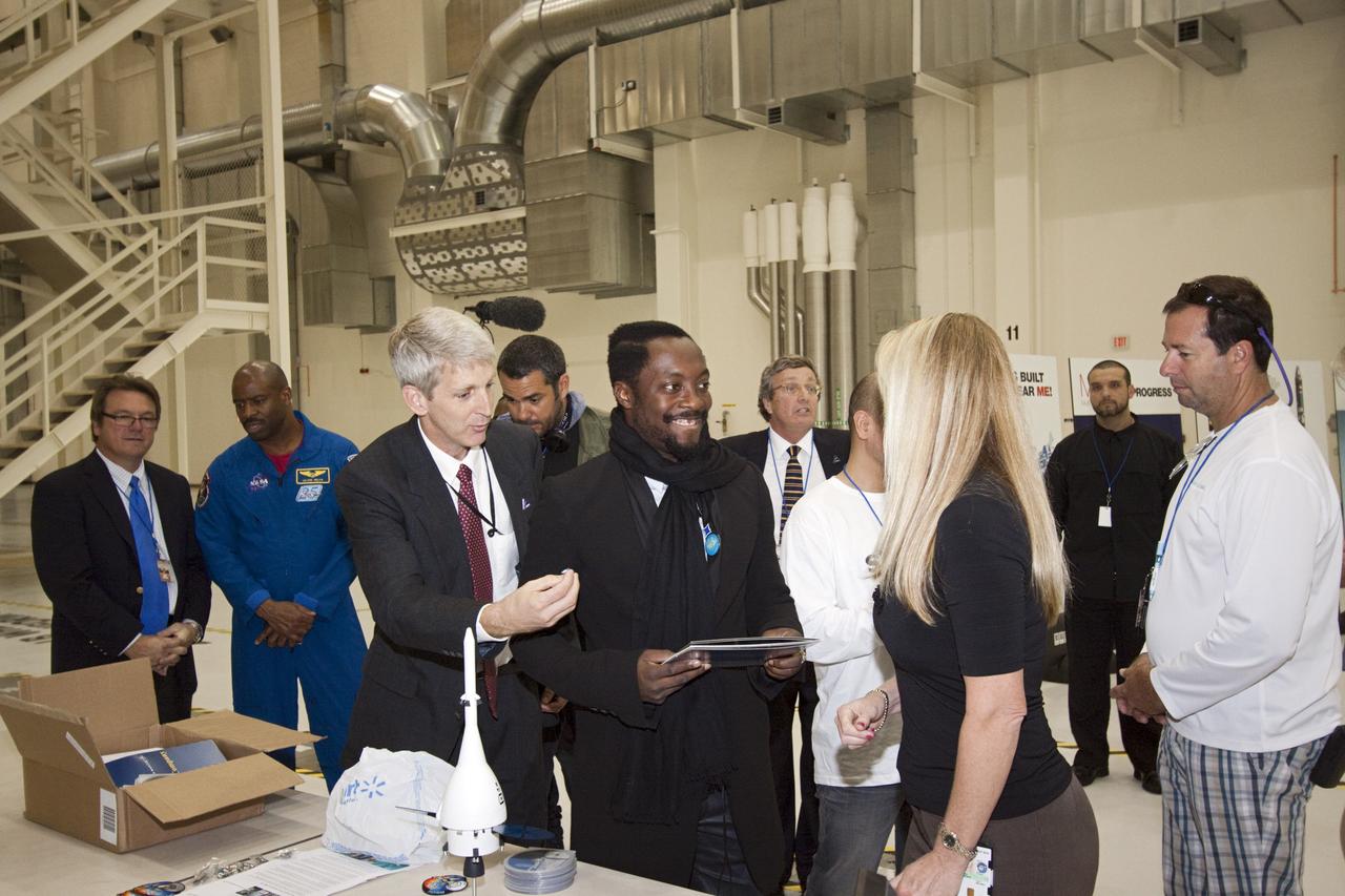 CAPE CANAVERAL, Fla. – At NASA Kennedy Space Center in Florida, Will.i.am (center), entertainer and member of The Black Eyed Peas, talks with employees on hand during his tour of the Operations and Checkout Building (O&C). The visit to the O&C followed his participation in a NASA Tweetup.     The Tweetup is part of prelaunch activities for the agency’s Mars Science Laboratory (MSL) launch and provides the opportunity for tweeters will share their experiences with followers through the social networking site Twitter. The MSL mission will pioneer precision landing technology and a sky-crane touchdown to place a car-sized rover, Curiosity, near the foot of a mountain inside Gale Crater on Aug. 6, 2012. During a nearly two-year prime mission after landing, the rover will investigate whether the region has ever offered conditions favorable for microbial life, including the chemical ingredients for life.  Liftoff of MSL aboard a United Launch Alliance Atlas V rocket from Space Launch Complex-41 on Cape Canaveral Air Force Station was at 10:02 a.m. EST on Nov. 26. For more information, visit http://www.nasa.gov/msl. Photo credit: NASA/Jim Grossmann