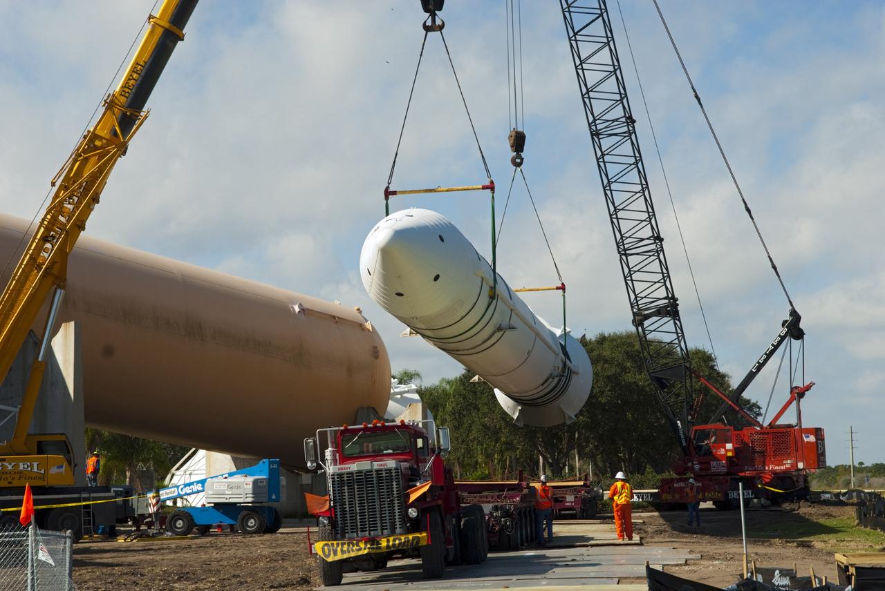 CAPE CANAVERAL, Fla. – Cranes remove a full-size, 149-foot-long, space shuttle solid rocket booster, or SRB, replica from the Kennedy Space Center Visitor Complex as the space-themed attraction makes way for a new exhibit featuring space shuttle Atlantis, which is currently undergoing preparations to go on public display. The SRB is being placed into temporary storage at NASA's Kennedy Space Center. The SRB was part of a mockup of the external tank and two SRBs at the visitor complex that were used to show visitors the size of actual space shuttle components. A space shuttle rode piggyback on the tank and boosters at liftoff and during the ascent into space. The SRBs burned out after about two-and-a-half minutes of flight. After recovery from the ocean, the boosters could be used repeatedly. Photo credit: NASA/Jim Grossmann