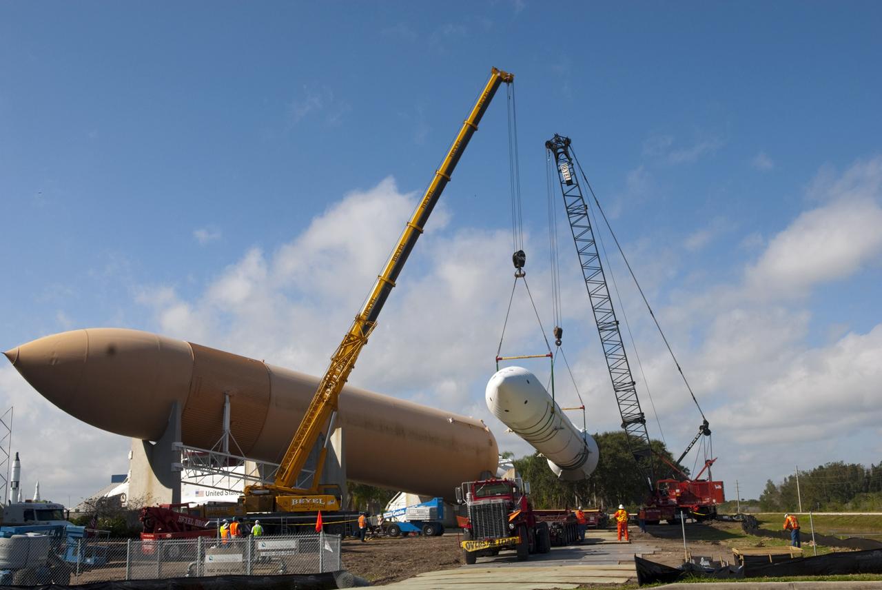 CAPE CANAVERAL, Fla. – Cranes remove a full-size, 149-foot-long, space shuttle solid rocket booster, or SRB, replica from the Kennedy Space Center Visitor Complex as the space-themed attraction makes way for a new exhibit featuring space shuttle Atlantis, which is currently undergoing preparations to go on public display. The SRB is being placed into temporary storage at NASA's Kennedy Space Center. The SRB was part of a mockup of the external tank and two SRBs at the visitor complex that were used to show visitors the size of actual space shuttle components. A space shuttle rode piggyback on the tank and boosters at liftoff and during the ascent into space. The SRBs burned out after about two-and-a-half minutes of flight. After recovery from the ocean, the boosters could be used repeatedly. Photo credit: NASA/Jim Grossmann