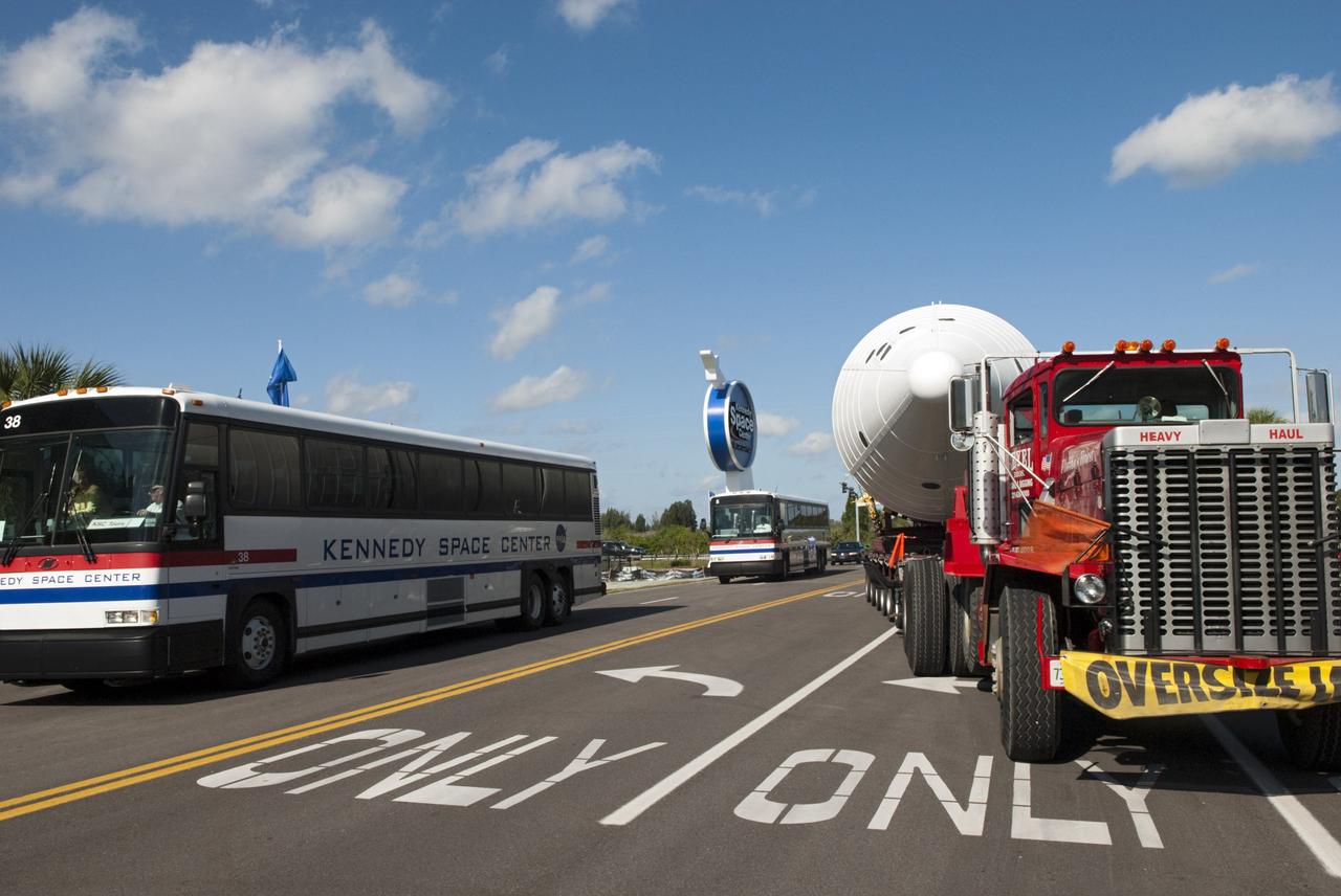 CAPE CANAVERAL, Fla. – A large truck hauls a full-size, 149-foot-long, space shuttle solid rocket booster, or SRB, replica from the Kennedy Space Center Visitor Complex as the space-themed attraction makes way for a new exhibit featuring space shuttle Atlantis, which is currently undergoing preparations to go on public display. The SRB is being placed into temporary storage at NASA's Kennedy Space Center. The SRB was part of a mockup of the external tank and two SRBs at the visitor complex that were used to show visitors the size of actual space shuttle components. A space shuttle rode piggyback on the tank and boosters at liftoff and during the ascent into space. The SRBs burned out after about two-and-a-half minutes of flight. After recovery from the ocean, the boosters could be used repeatedly. Photo credit: NASA/Jim Grossmann