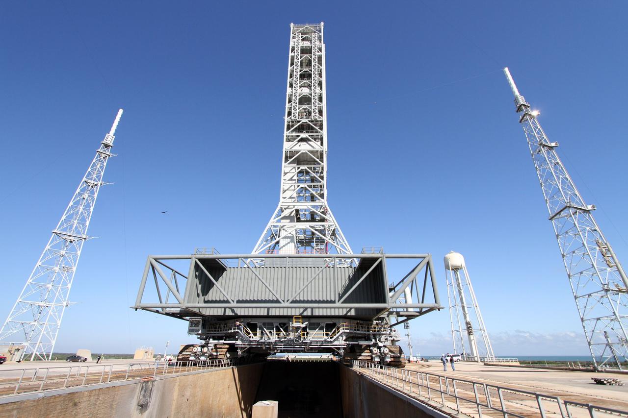 CAPE CANAVERAL, Fla. – A crawler-transporter straddles the flame trench on Launch Pad 39B at NASA's Kennedy Space Center in Florida.  The crawler is returning the mobile launcher, or ML, back to the park site near the Vehicle Assembly Building.      Data on the ML collected from structural and functional engineering tests during its two-week stay on the pad will be used in the next phases of construction. The 355-foot-tall ML structure, which took about two years to construct, will be modified by NASA’s 21st Century Ground Systems Program to support NASA’s Space Launch System, the heavy-lift rocket that will launch astronauts into deep space on future exploration missions. For more information, visit http://www.nasa.gov/exploration/systems/sls. Photo credit: NASA/Cory Huston