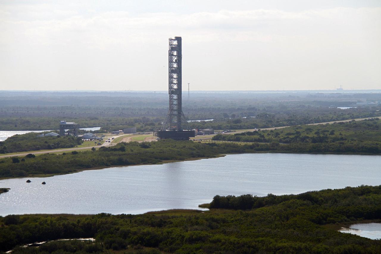 CAPE CANAVERAL, Fla. – The mobile launcher, or ML, passes by the Launch Complex 39 Observation Gantry at NASA's Kennedy Space Center in Florida as it makes the 4.2-mile trek from Launch Pad 39B to the park site near the Vehicle Assembly Building.    Data on the ML collected from structural and functional engineering tests during its two-week stay on the pad will be used in the next phases of construction. The 355-foot-tall ML structure, which took about two years to construct, will be modified by NASA’s 21st Century Ground Systems Program to support NASA’s Space Launch System, the heavy-lift rocket that will launch astronauts into deep space on future exploration missions. For more information, visit http://www.nasa.gov/exploration/systems/sls. Photo credit: NASA/Cory Huston