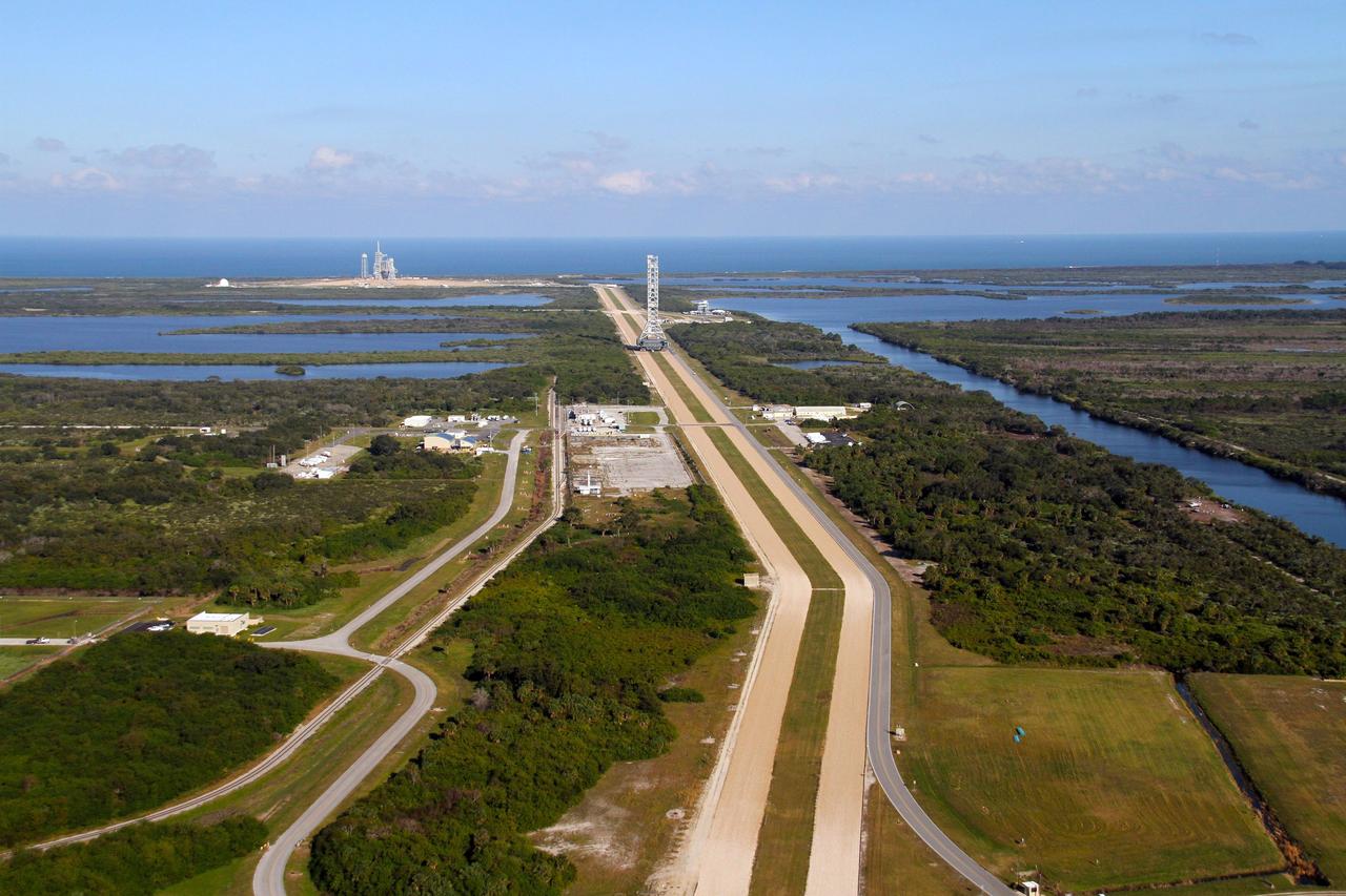 CAPE CANAVERAL, Fla. – The mobile launcher, or ML, makes steady progress on its 4.2-mile trek from Launch Pad 39B to the park site near the Vehicle Assembly Building at NASA's Kennedy Space Center in Florida.  The Atlantic Ocean spans the view, in the background, behind Launch Pad 39A.    Data on the ML collected from structural and functional engineering tests during its two-week stay on the pad will be used in the next phases of construction. The 355-foot-tall ML structure, which took about two years to construct, will be modified by NASA’s 21st Century Ground Systems Program to support NASA’s Space Launch System, the heavy-lift rocket that will launch astronauts into deep space on future exploration missions. For more information, visit http://www.nasa.gov/exploration/systems/sls. Photo credit: NASA/Cory Huston