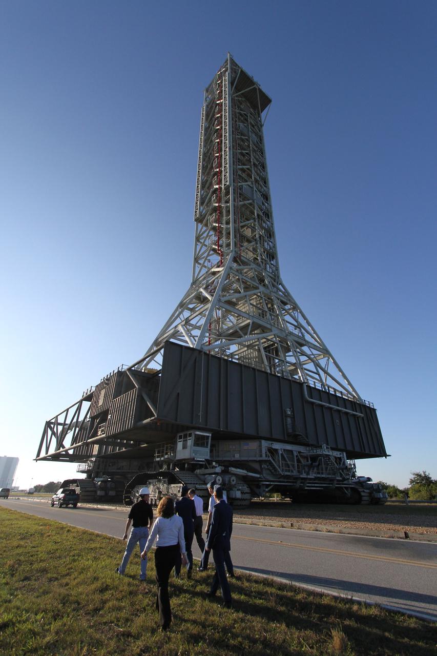 CAPE CANAVERAL, Fla. – Kennedy Space Center Director Robert Cabana (white shirt in front of group) and other support personnel accompany the mobile launcher, or ML, as it rolls from Launch Pad 39B to the park site near the Vehicle Assembly Building at NASA's Kennedy Space Center in Florida.    Data on the ML collected from structural and functional engineering tests during its two-week stay on the pad will be used in the next phases of construction. The 355-foot-tall ML structure, which took about two years to construct, will be modified by NASA’s 21st Century Ground Systems Program to support NASA’s Space Launch System, the heavy-lift rocket that will launch astronauts into deep space on future exploration missions. For more information, visit http://www.nasa.gov/exploration/systems/sls. Photo credit: NASA/Cory Huston